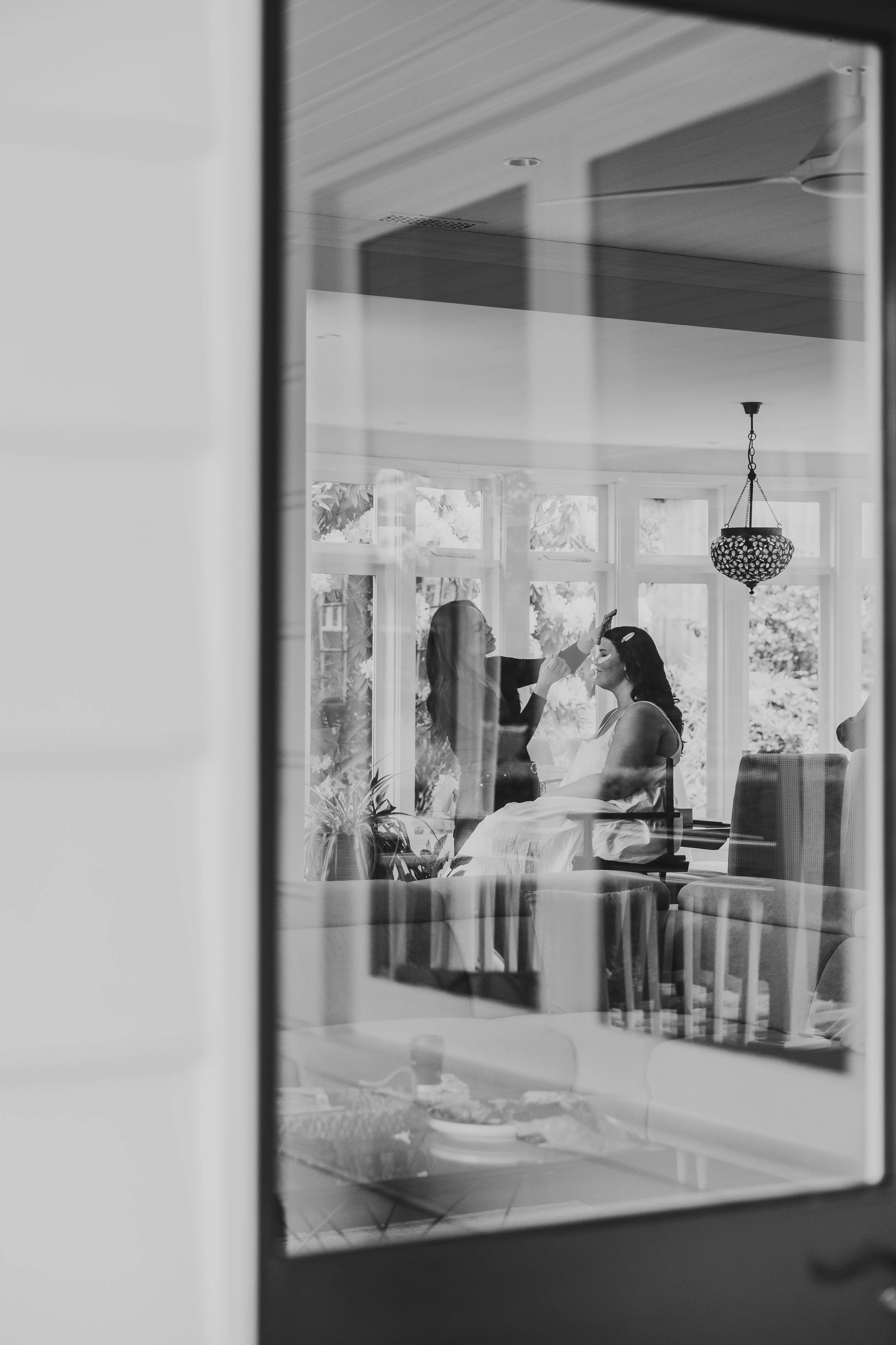 bride getting ready for wedding having make up done