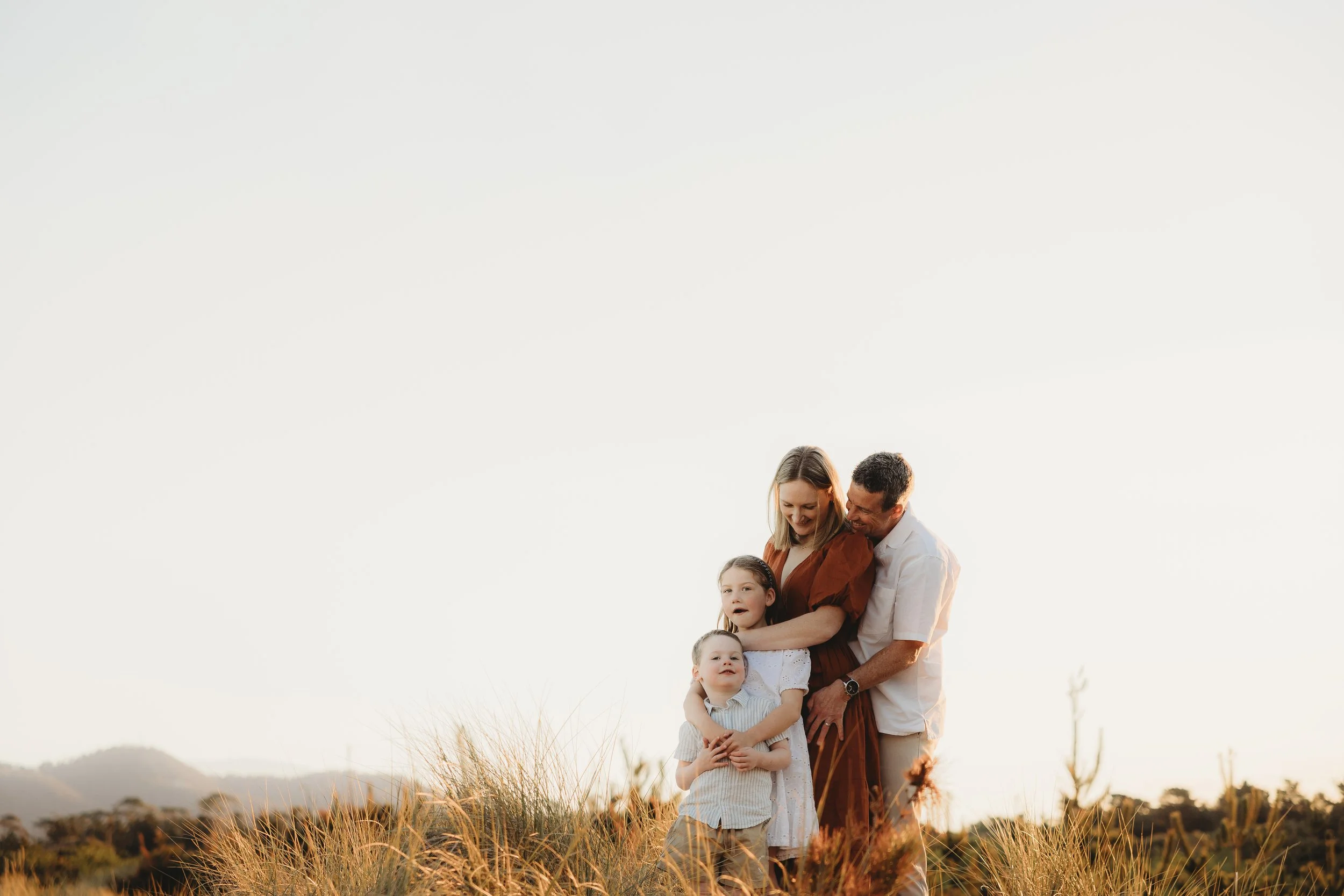 family on beach at golden hour all hugging