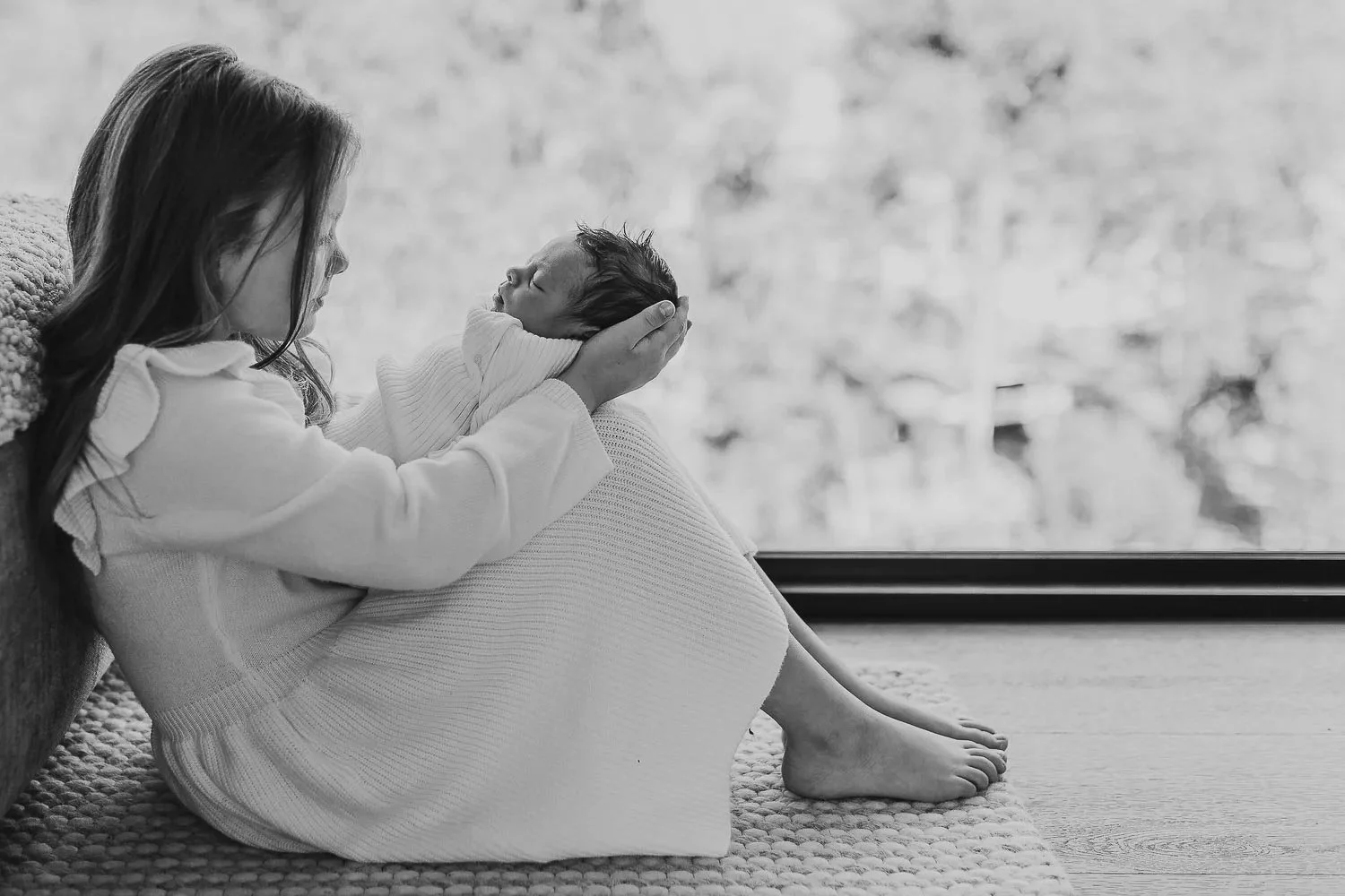 big sister holding newborn baby sister