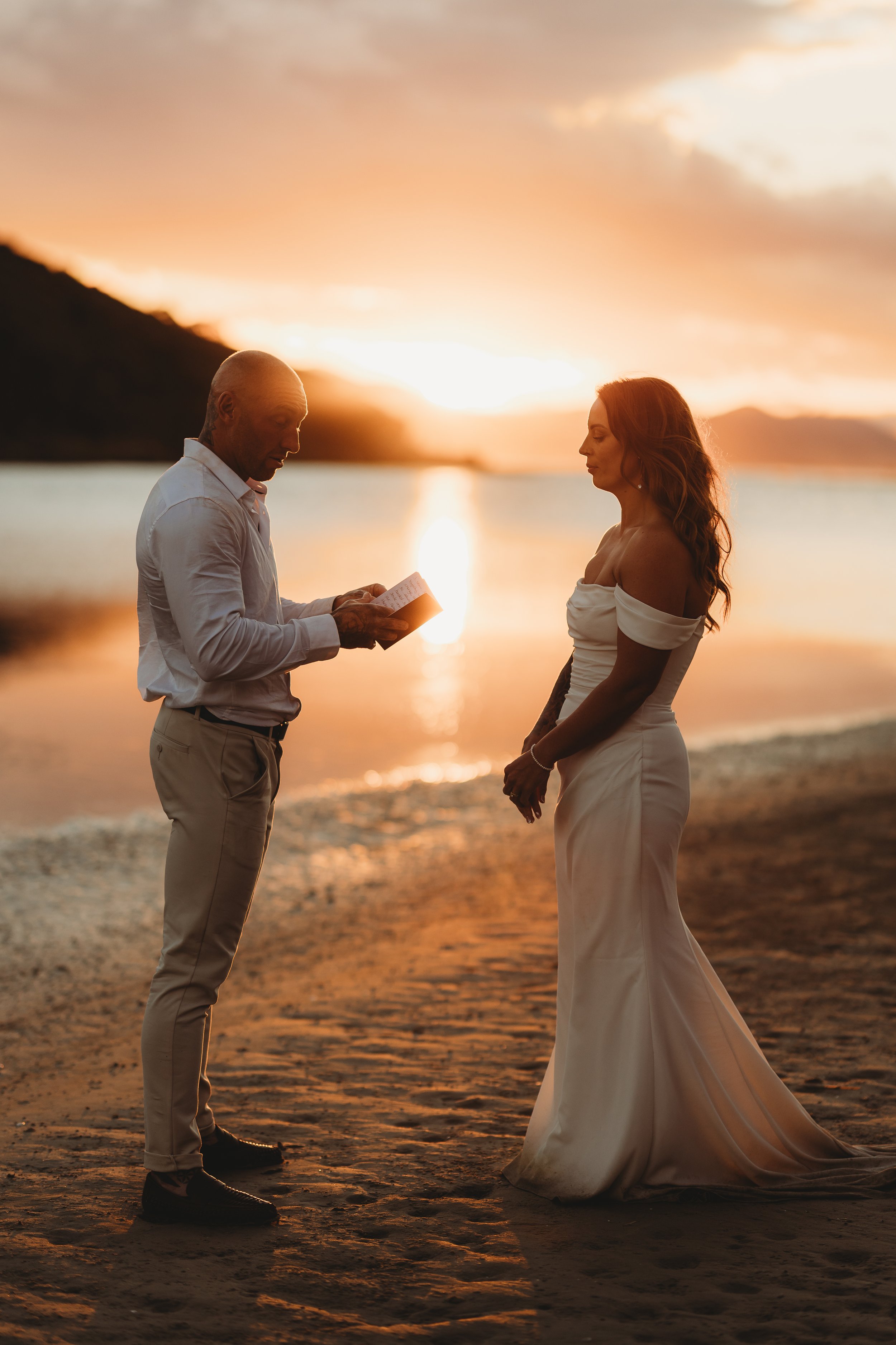 bride and groom sharing vows on wedding day at sunset