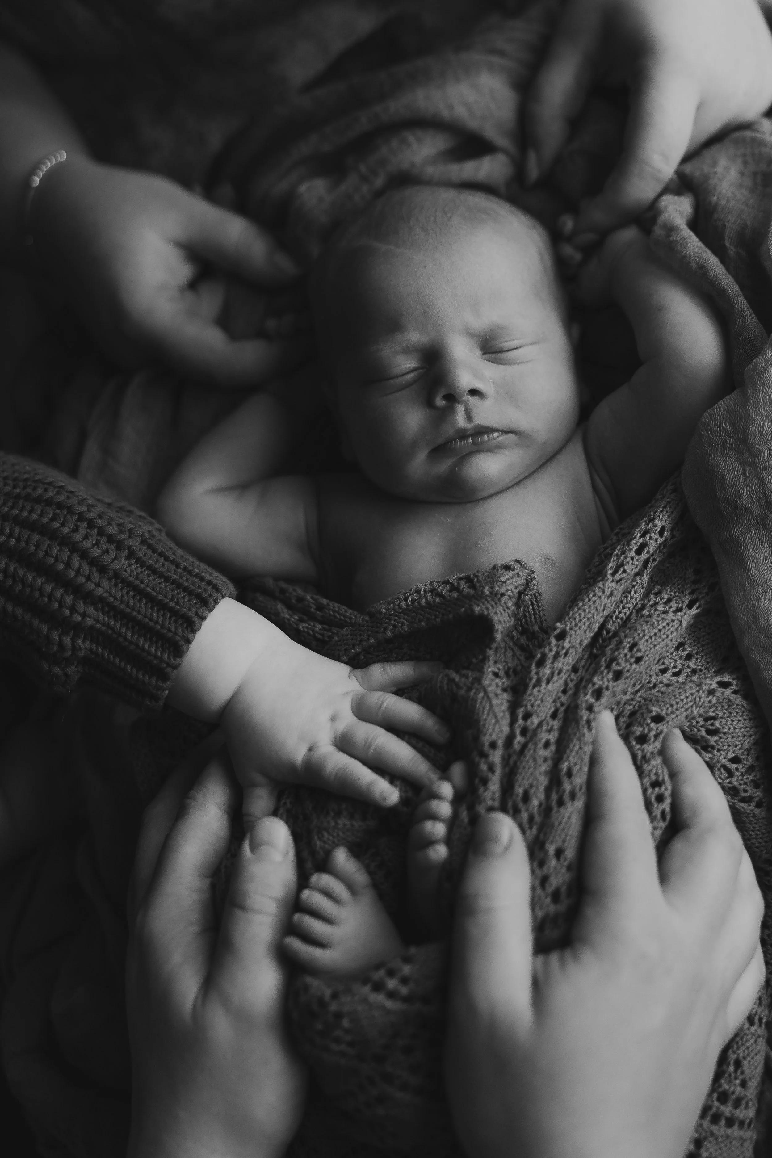 Newborn baby sleeping with mums hand holding their face