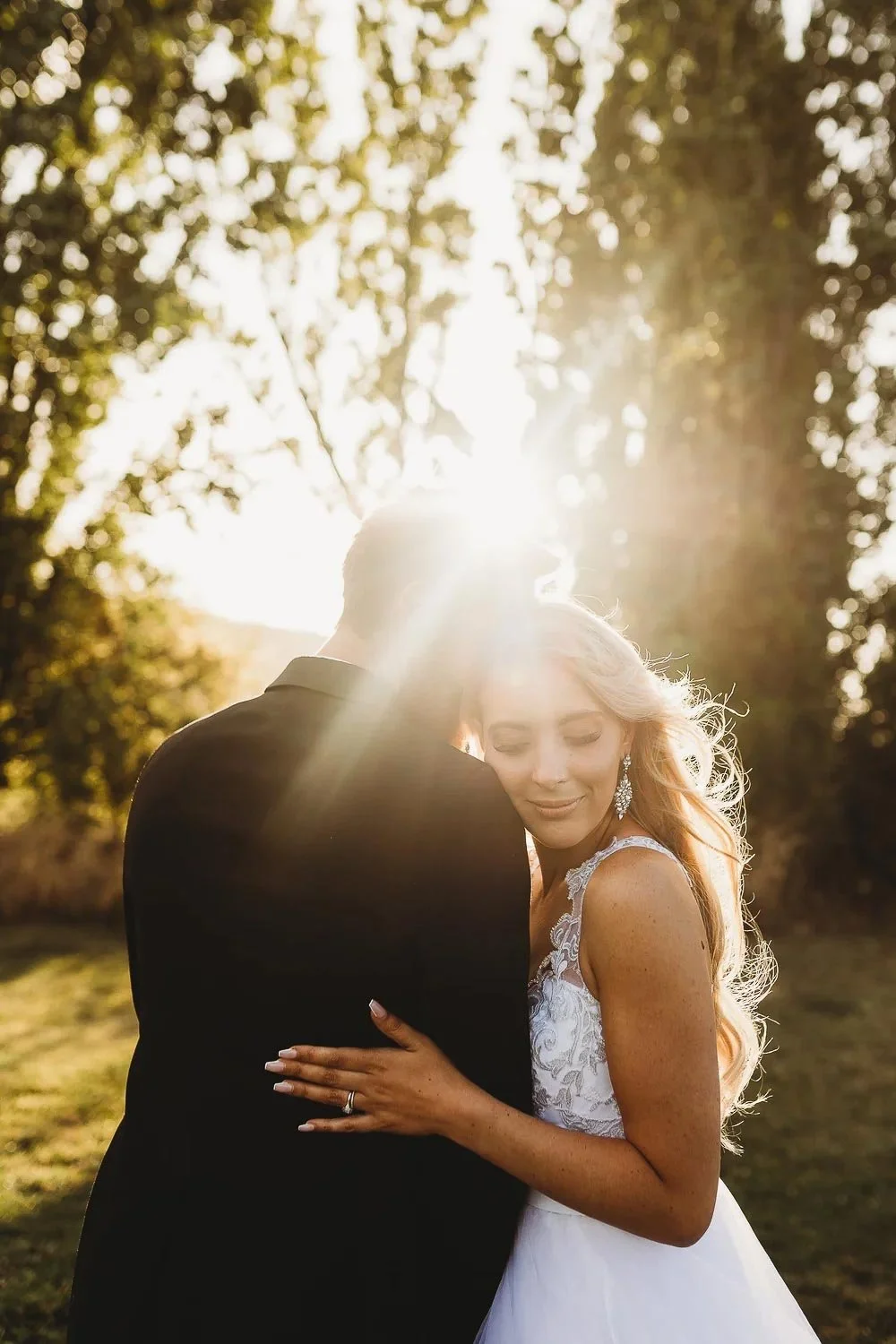Bride snuggled into Groom holding his shoulder