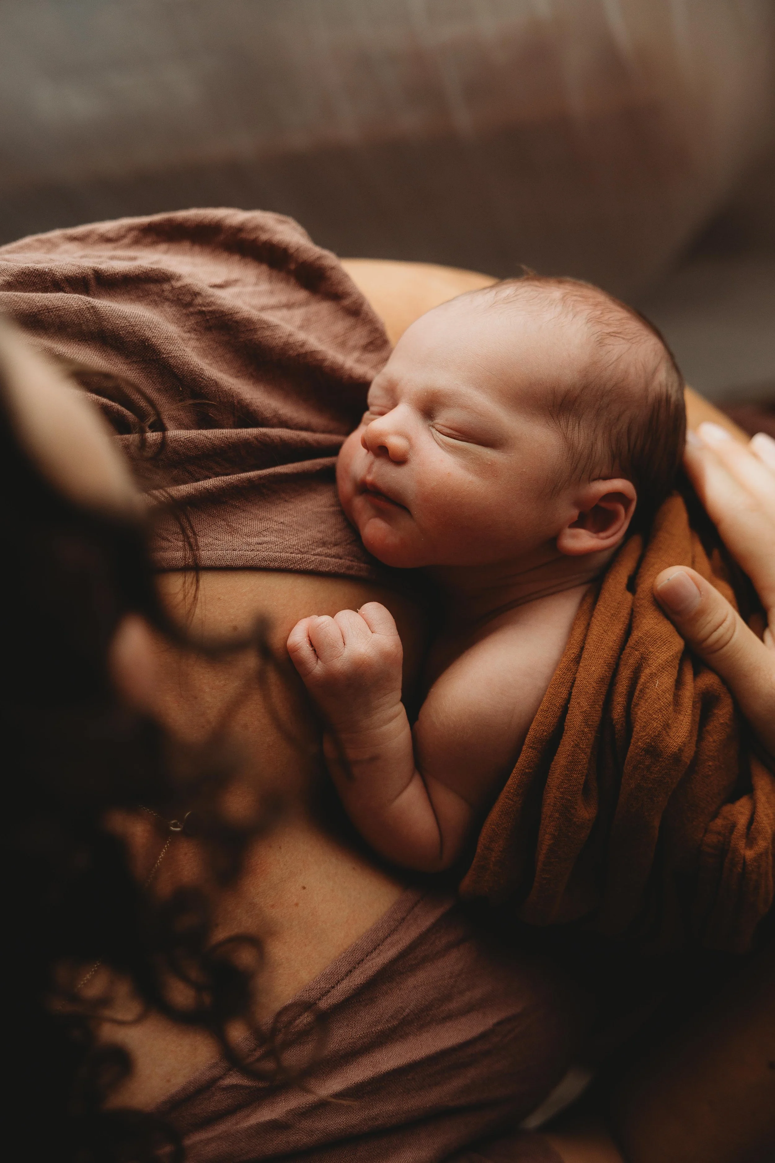 newborn baby resting on mums chest