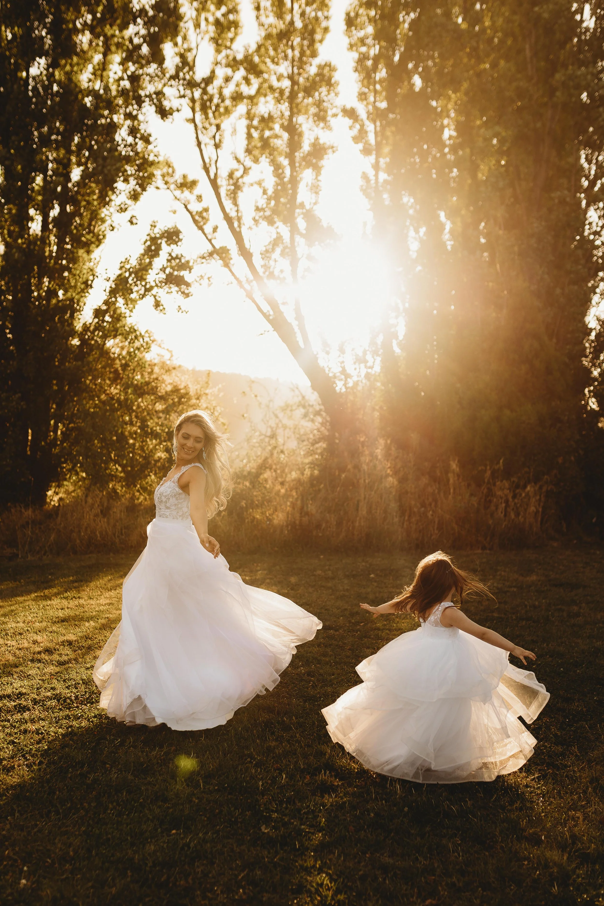mum and daughter twirling in the golden sunset on wedding day