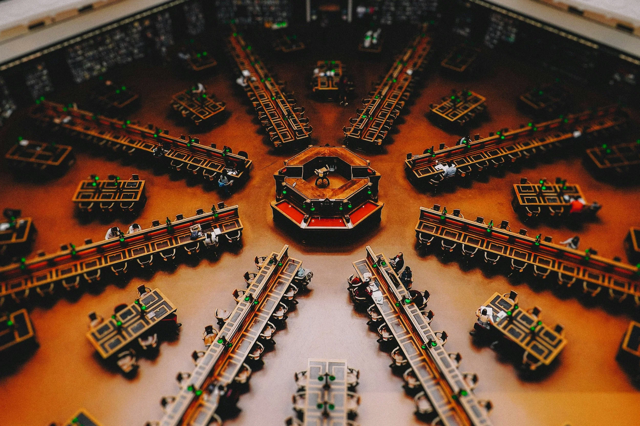 Overhead view of a highly organized, symmetrical room with radiating desks, symbolizing expert corporate structuring, governance, and the proper establishmenet of UAE regulatory alignment.