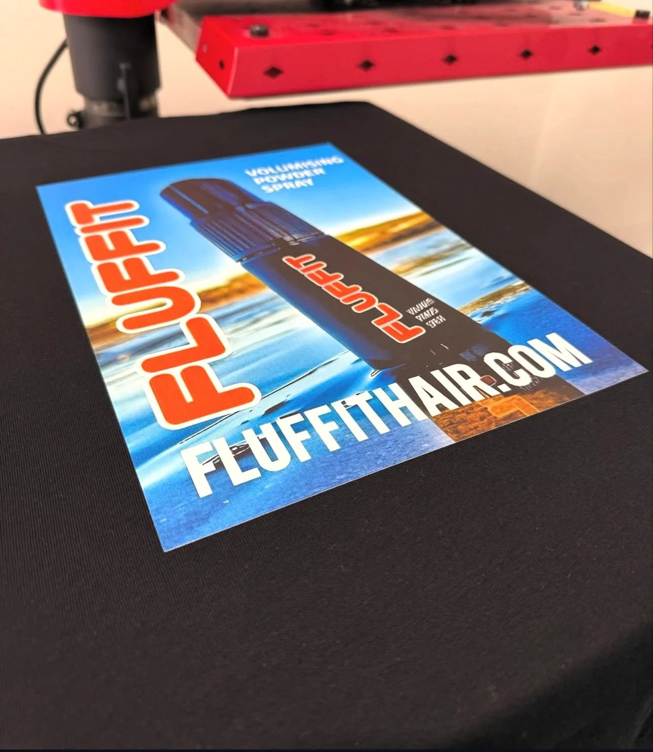 A flyer for a volunteer water spray event from FLUFFTHAIR.com, featuring a large black and red flashlight over a body of water at sunset.
