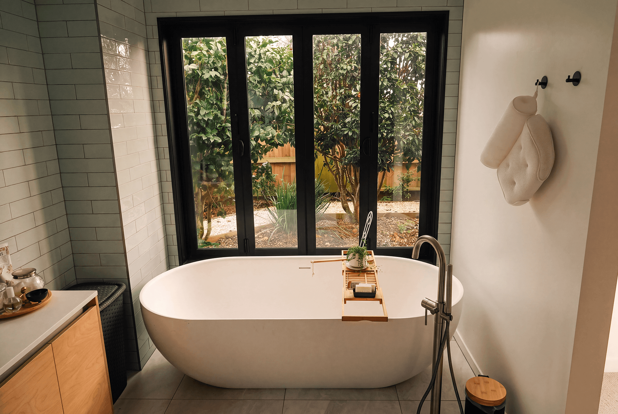 Adams Building contemporary bathroom with freestanding bath, tiled walls and garden outlook in Fitzroy, New Plymouth.
