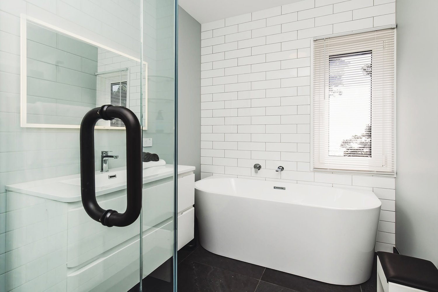 Adams Building contemporary bathroom with freestanding bath, tiled flooring and modern finishes in New Plymouth, Taranaki.