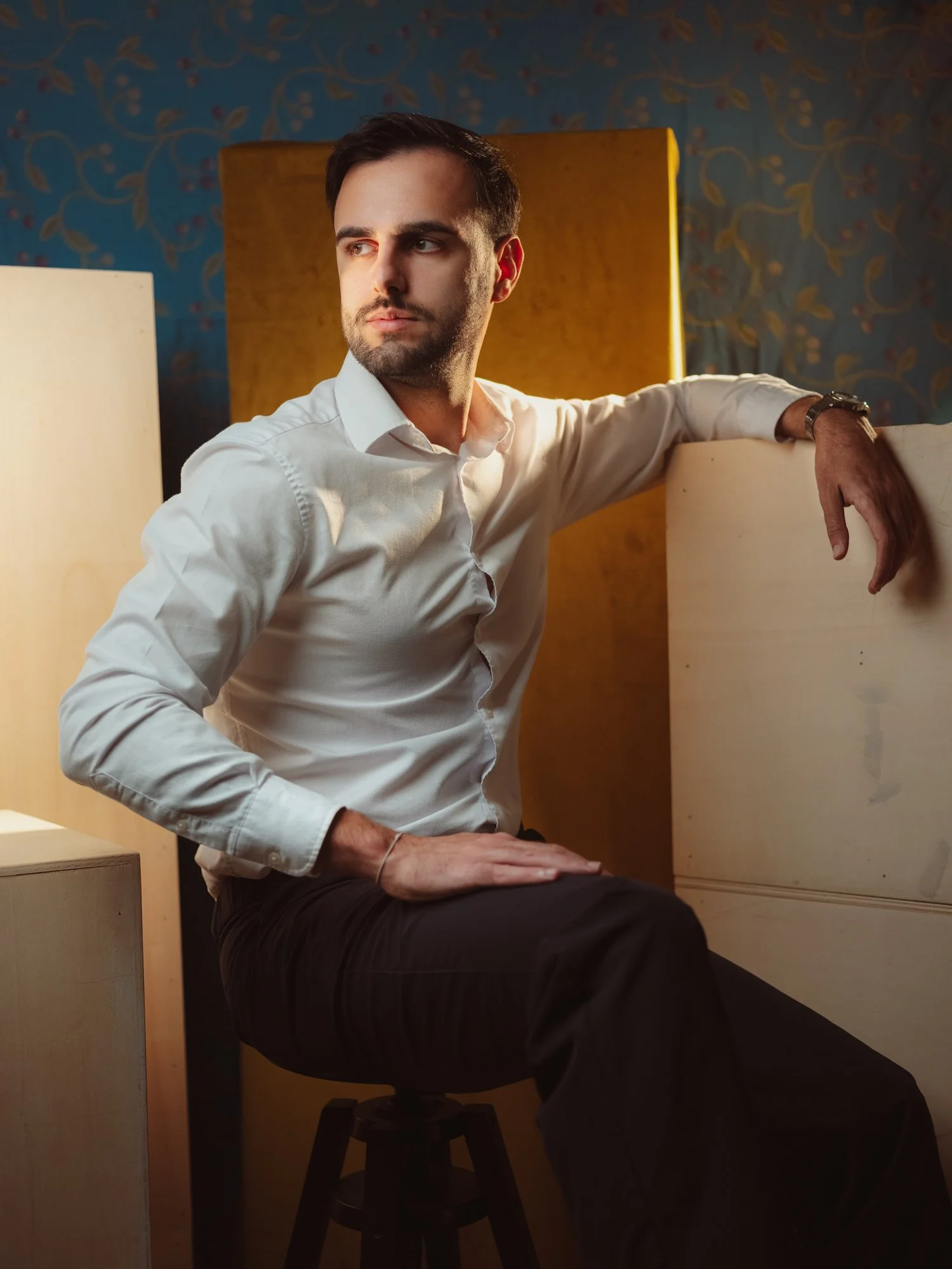 Uomo in camicia bianca in posa elegante e naturale nel ritratto di studio