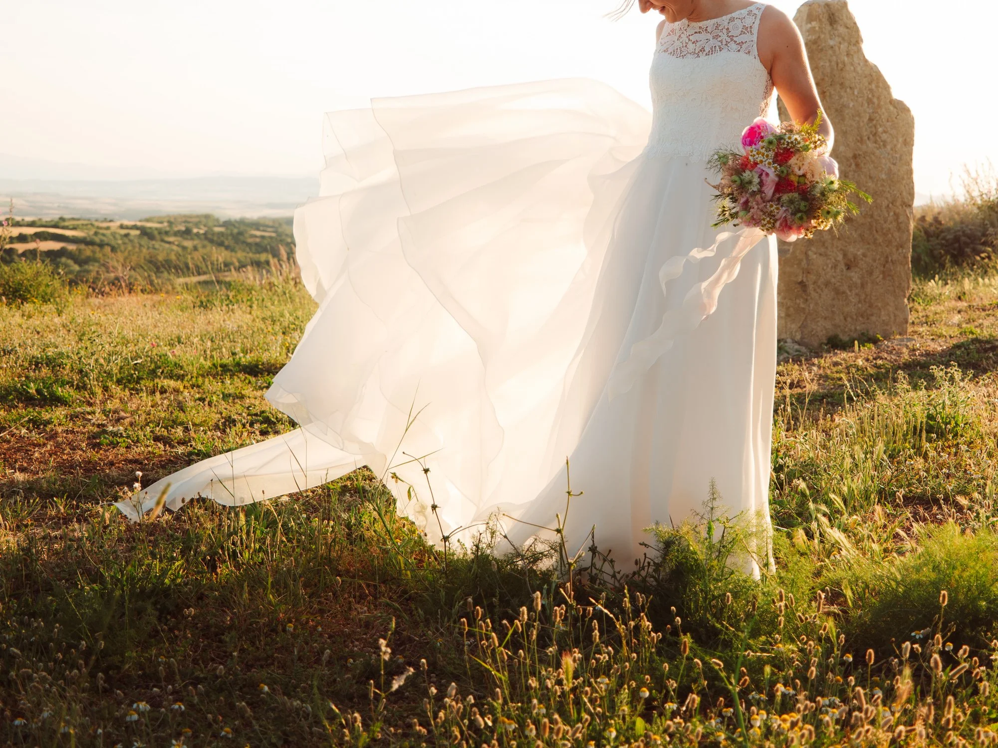 Dettaglio del tessuto dell'abito da sposa che fluttua al vento al tramonto
