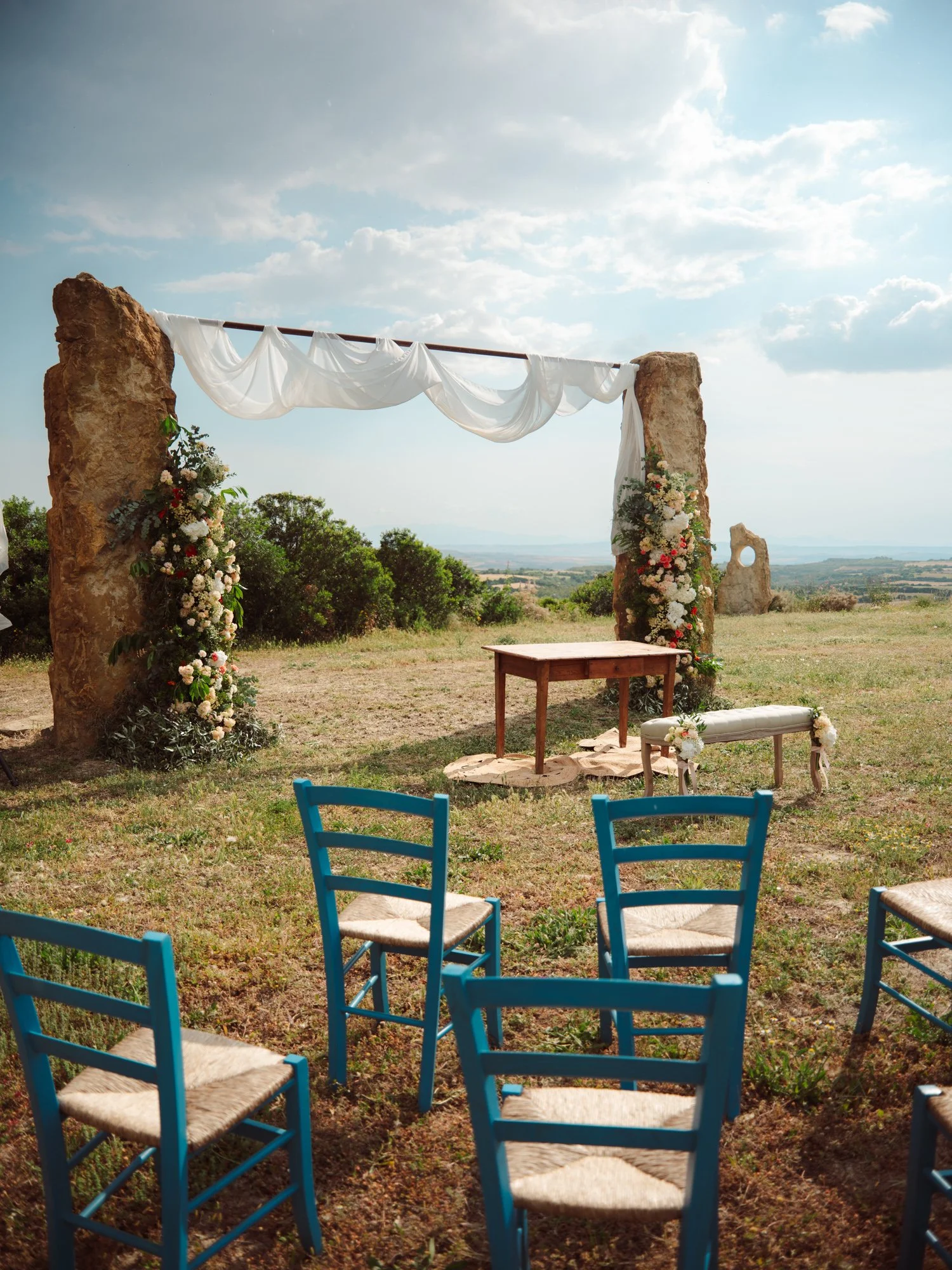 Arco floreale decorato e sedie azzurre per cerimonia di matrimonio in stile country chic in Sardegna