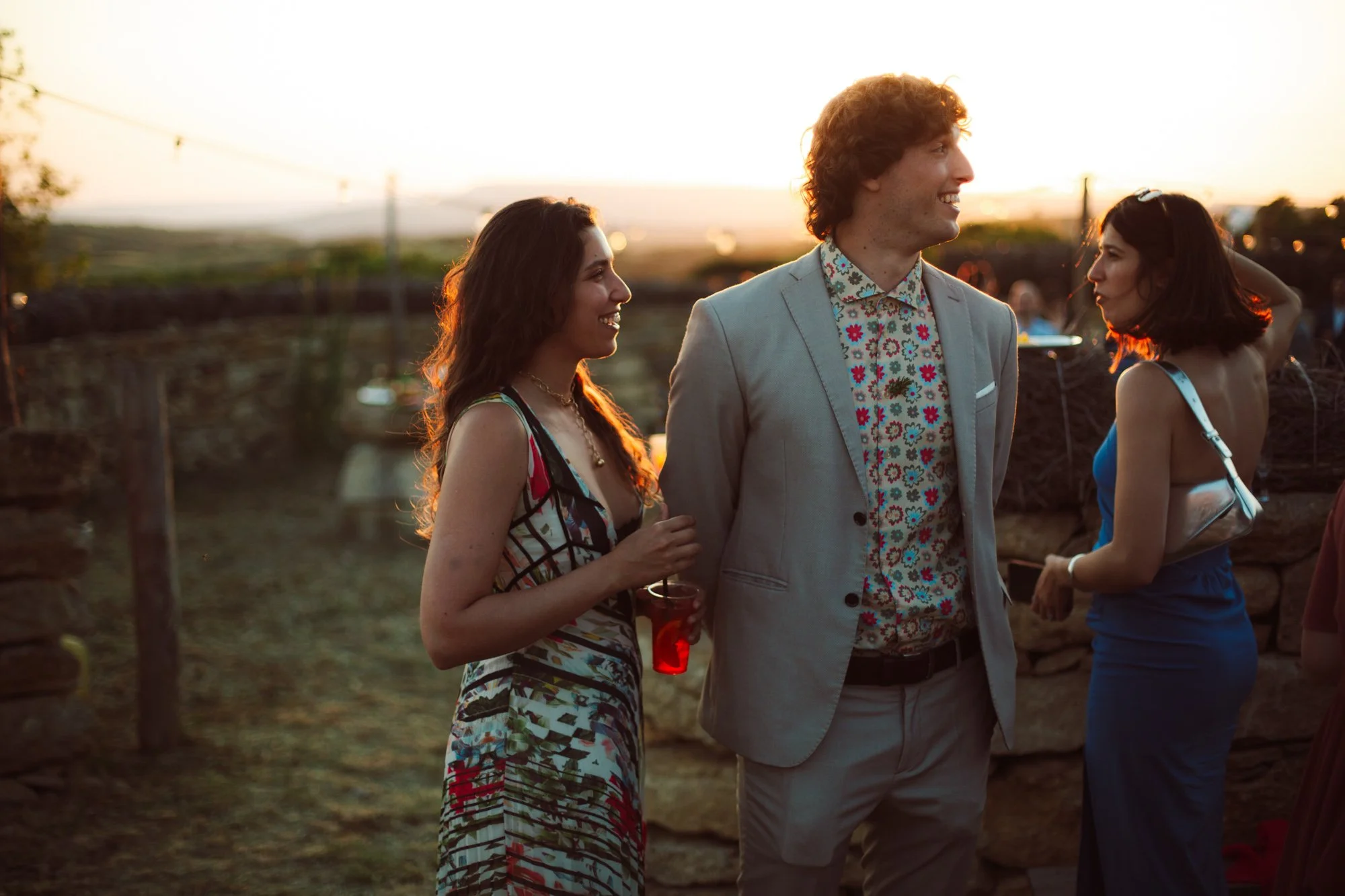Invitati a un matrimonio in campagna mentre si godono un drink al tramonto
