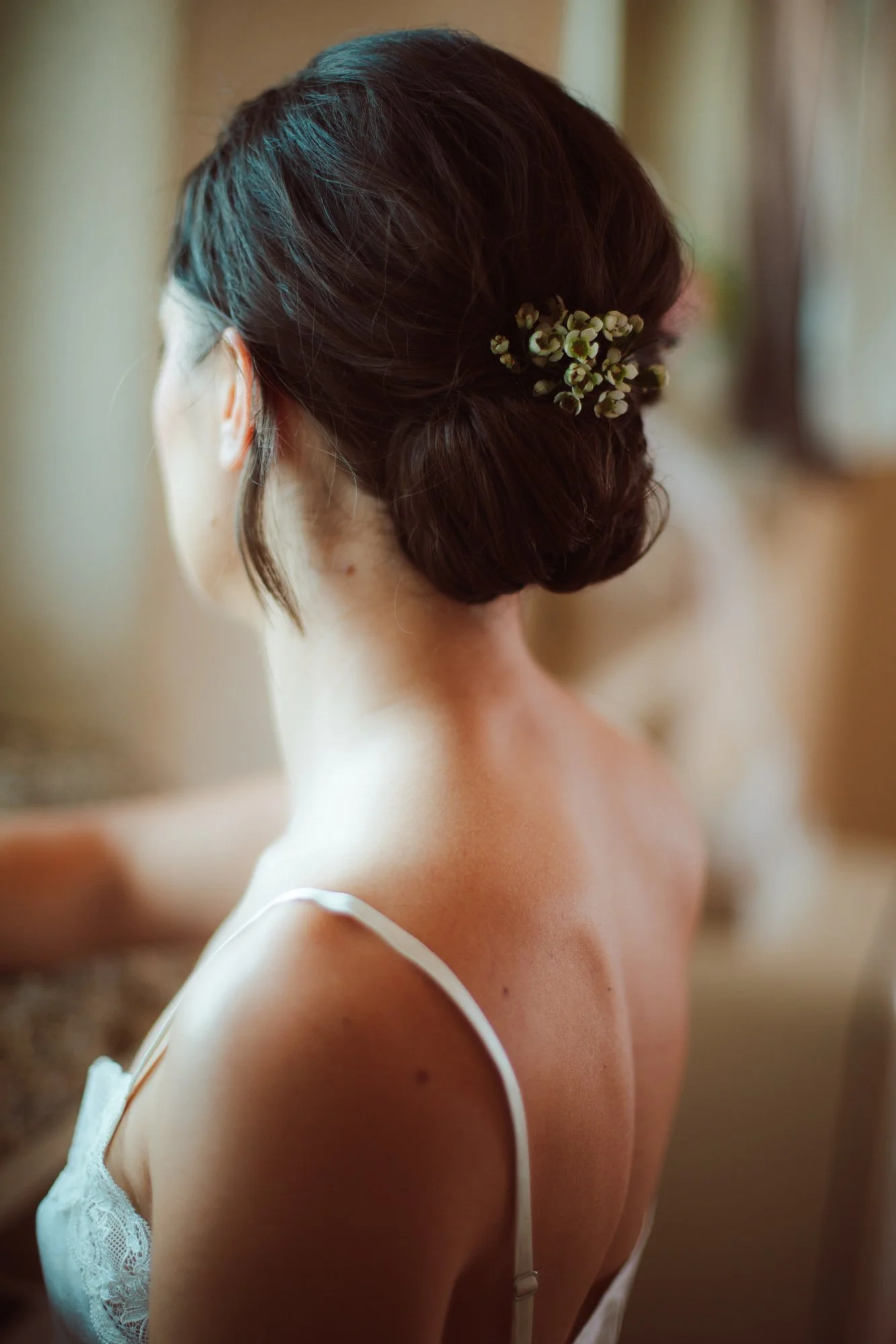 Acconciatura da sposa con capelli raccolti e dettagli floreali
