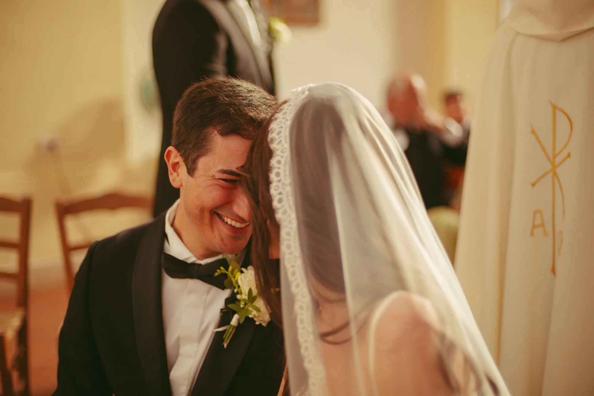 Momento intimo e divertito tra sposo e sposa che sorridono vicini durante la celebrazione del matrimonio