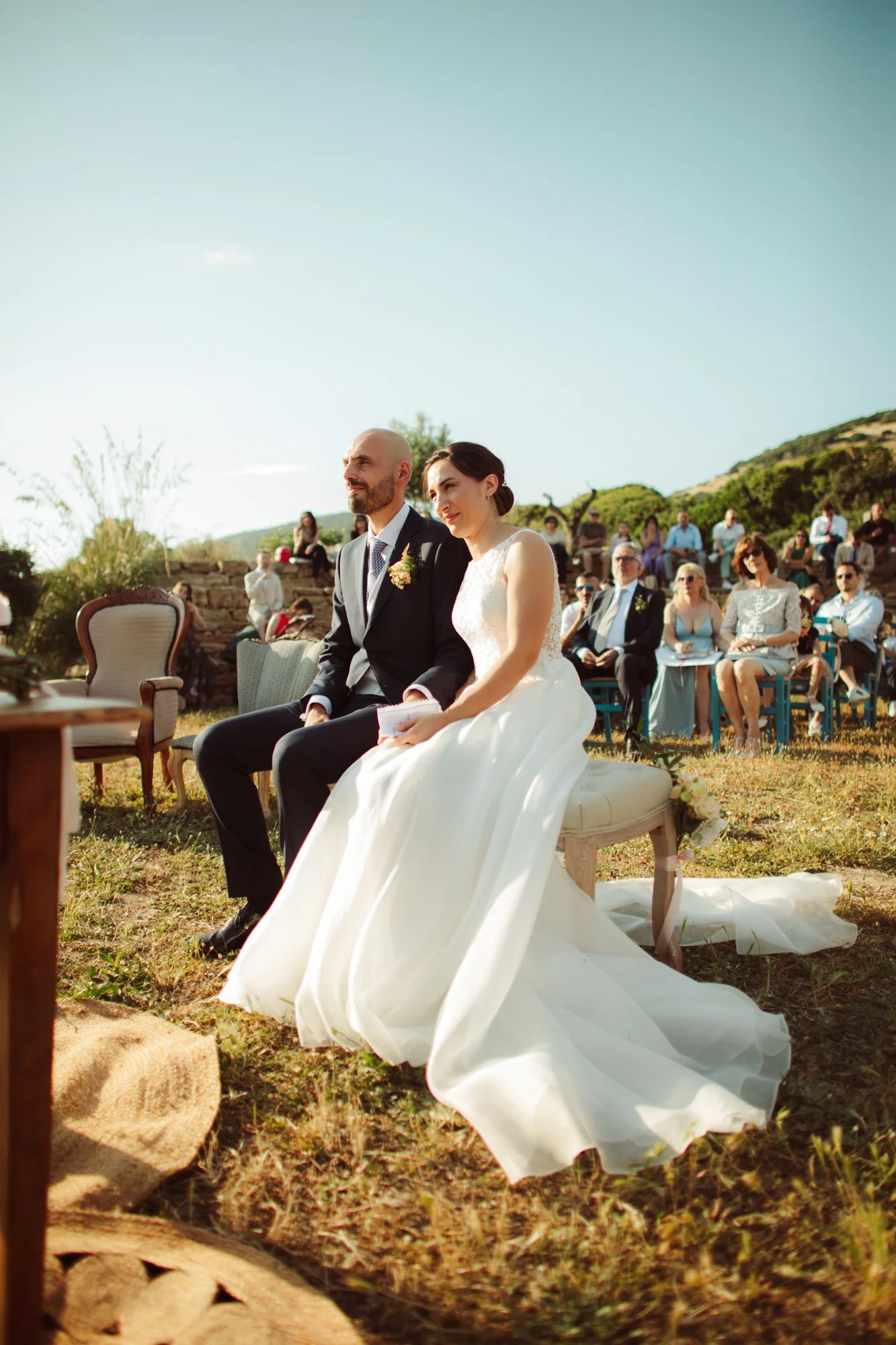 Gli sposi seduti durante la cerimonia di matrimonio all'aperto in Sardegna