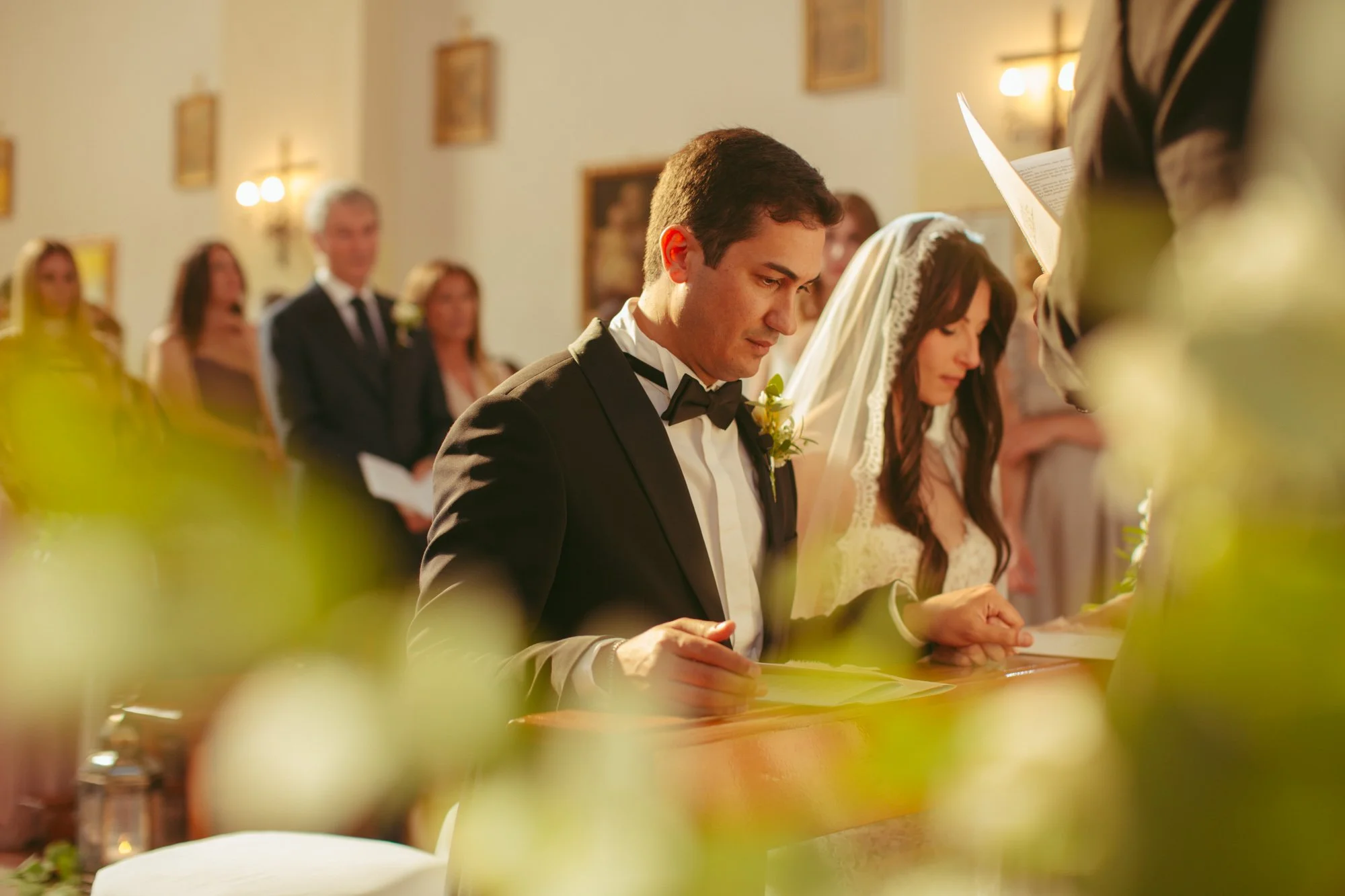 Gli sposi seduti all'altare intenti ad ascoltare la celebrazione del matrimonio religioso