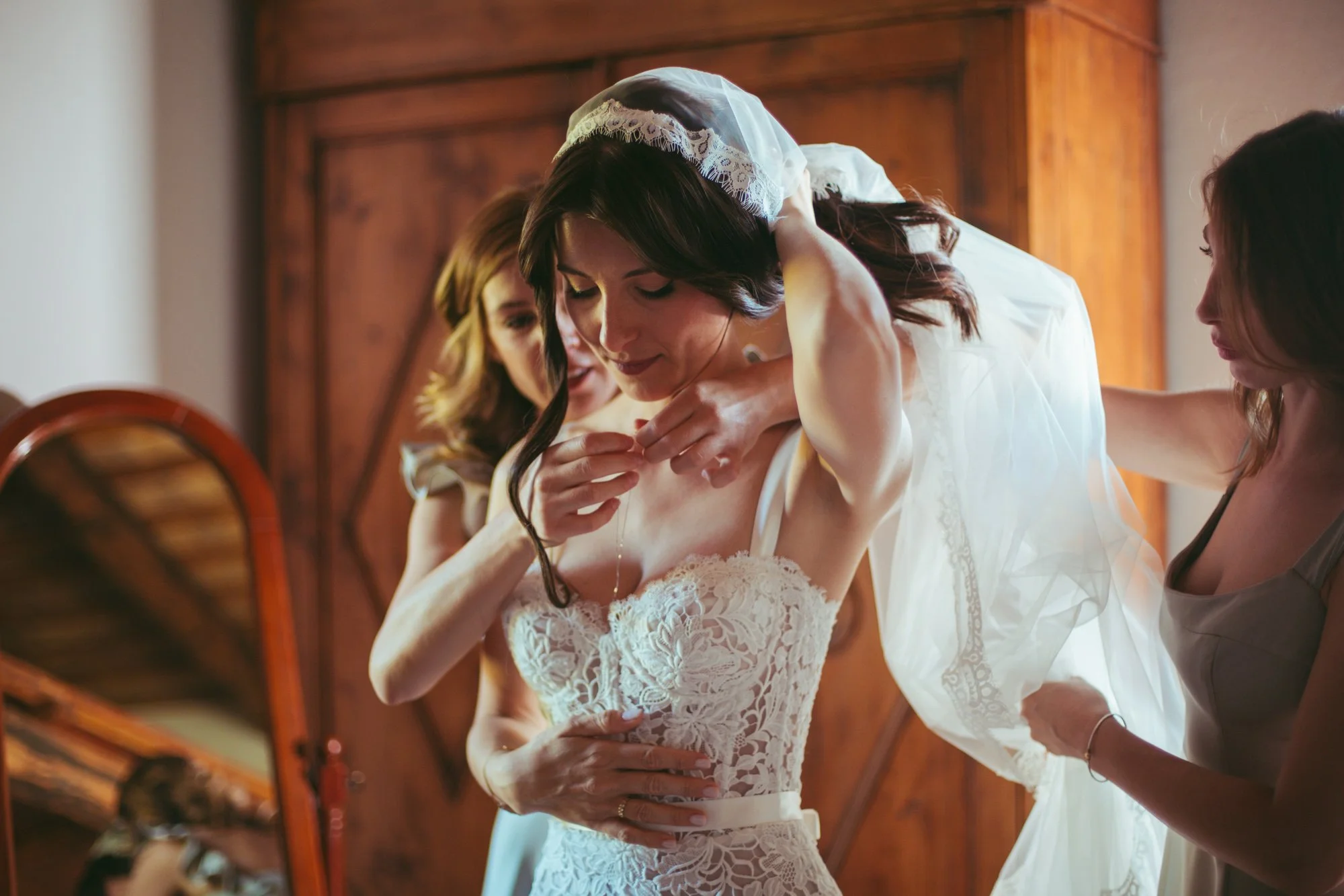 Le damigelle aiutano la sposa a indossare la collana e sistemare il velo