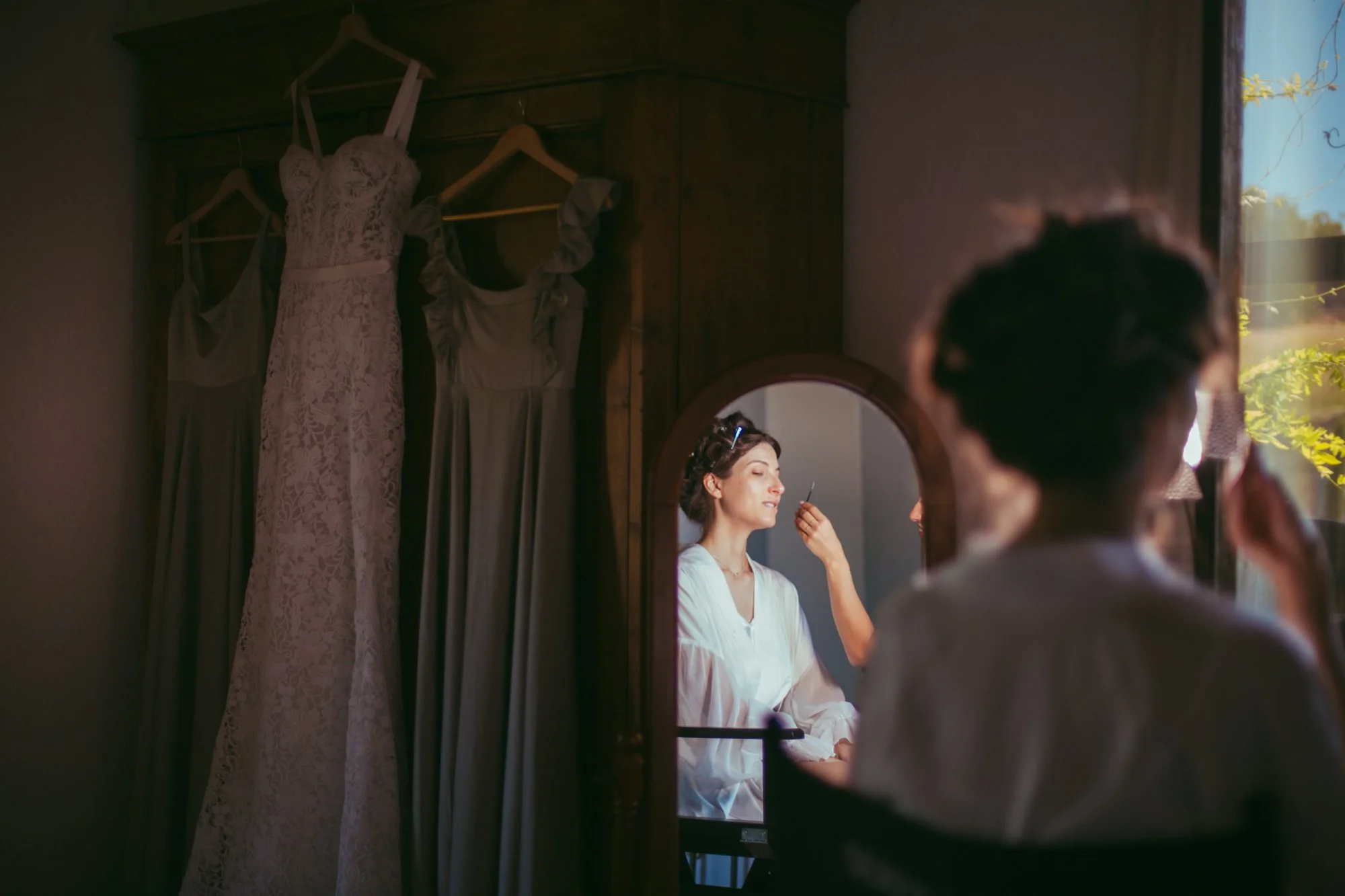 Sposa al trucco riflessa nello specchio durante i preparativi prima della cerimonia