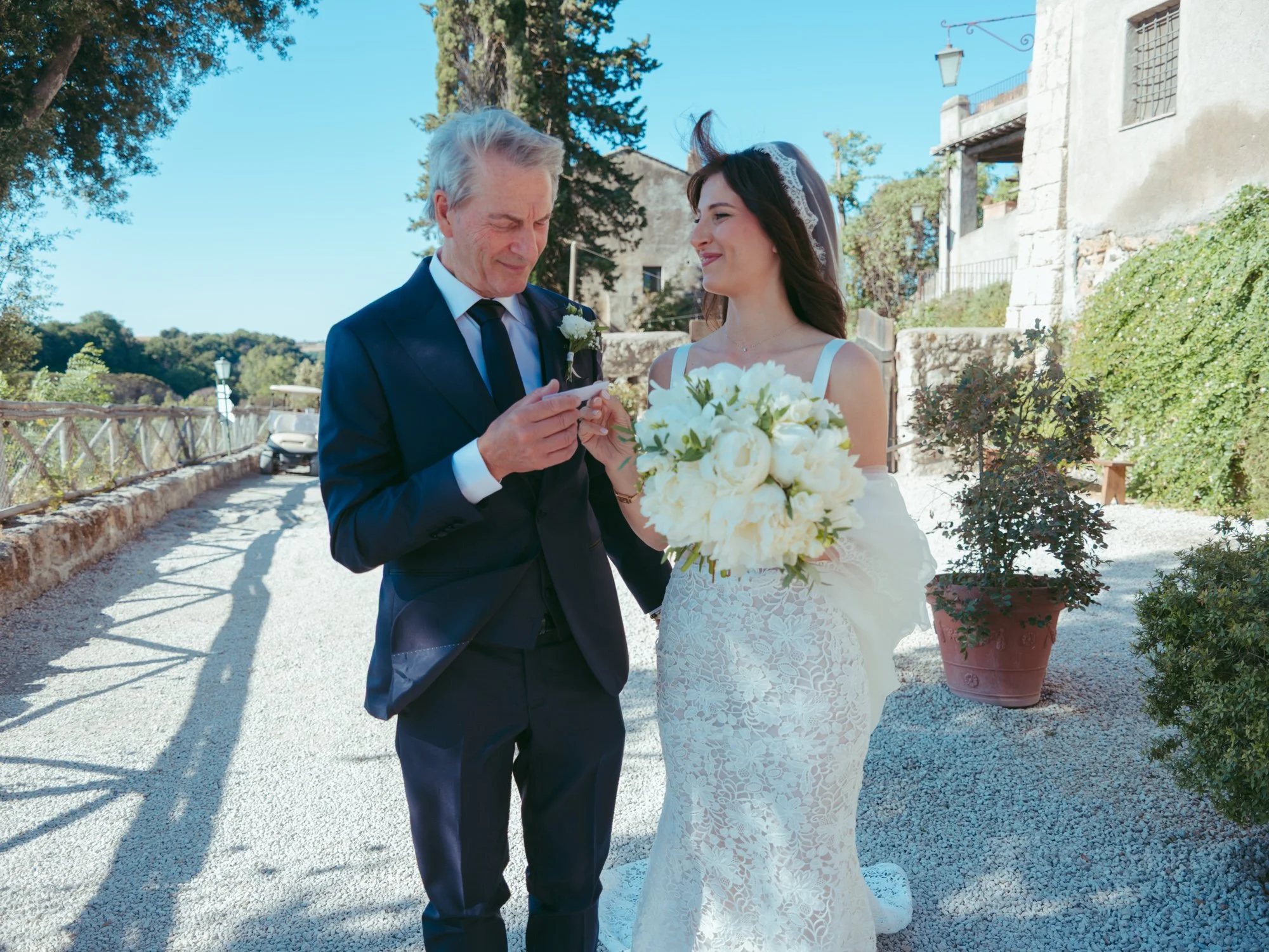 Il padre legge un biglietto alla figlia prima delle nozze mentre la sposa lo guarda sorridente