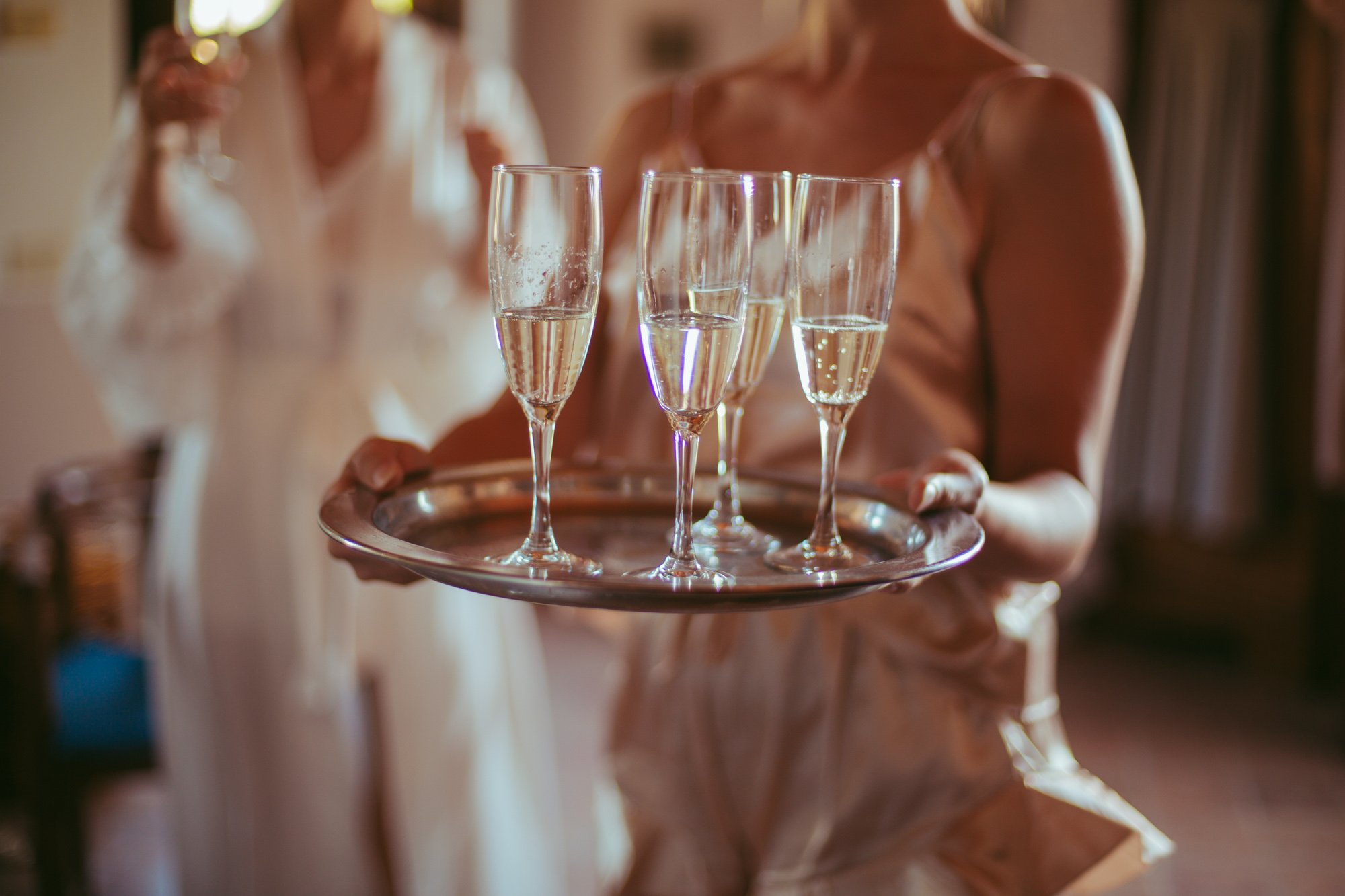 Calici di spumante su un vassoio d'argento durante i preparativi della sposa e delle damigelle