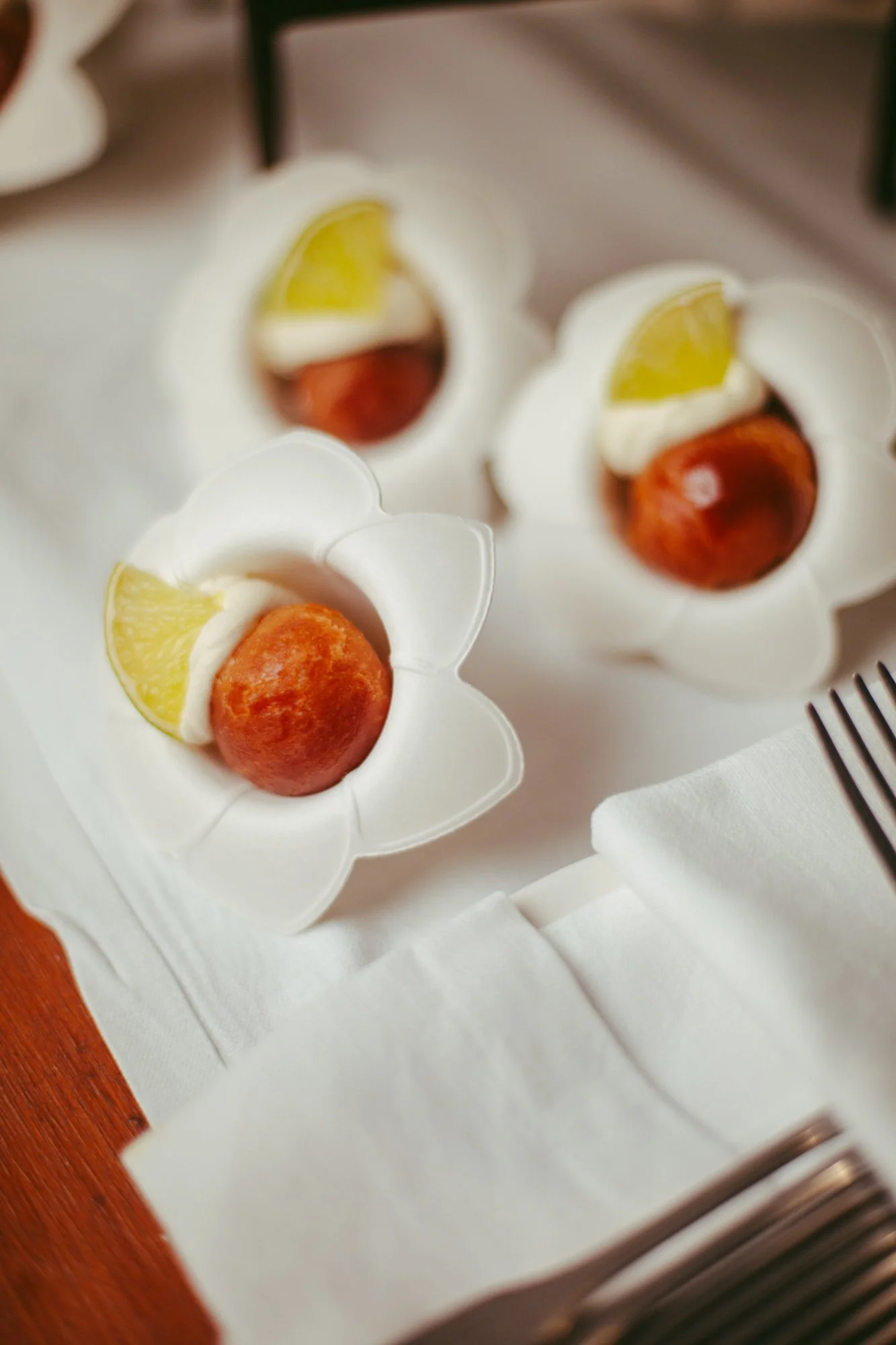 Dettaglio di piccoli babà monoporzione serviti su pirottini a forma di fiore per il buffet dei dolci a Borgo di Tragliata
