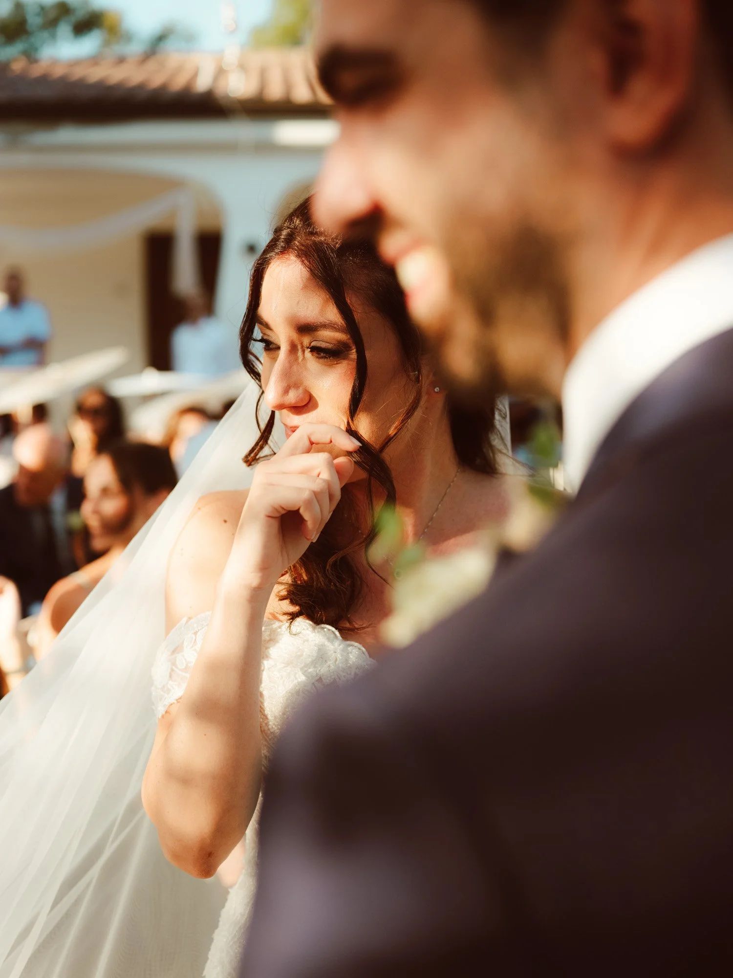 La sposa commossa si asciuga una lacrima di gioia accanto allo sposo durante la cerimonia nuziale.