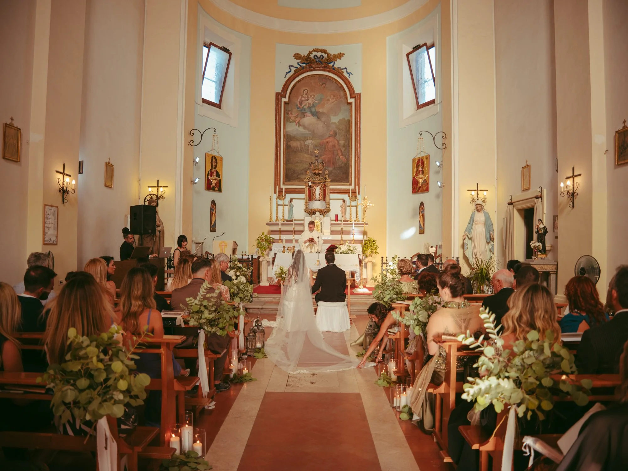 Vista panoramica dall'interno della chiesa decorata con eucalipto e lanterne mentre gli sposi si trovano all'altare