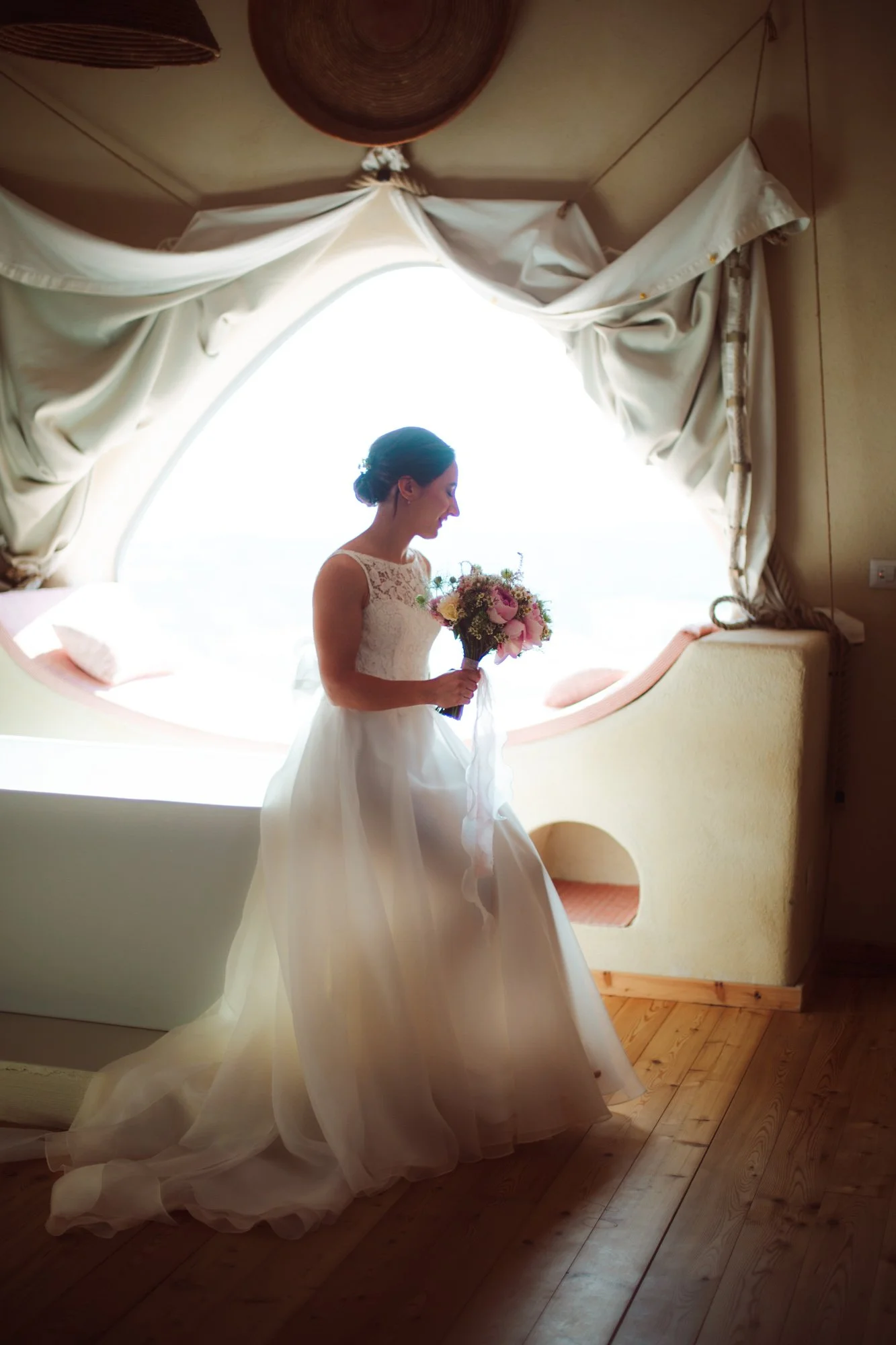 Sposa in abito bianco con bouquet in mano prima della cerimonia in Sardegna