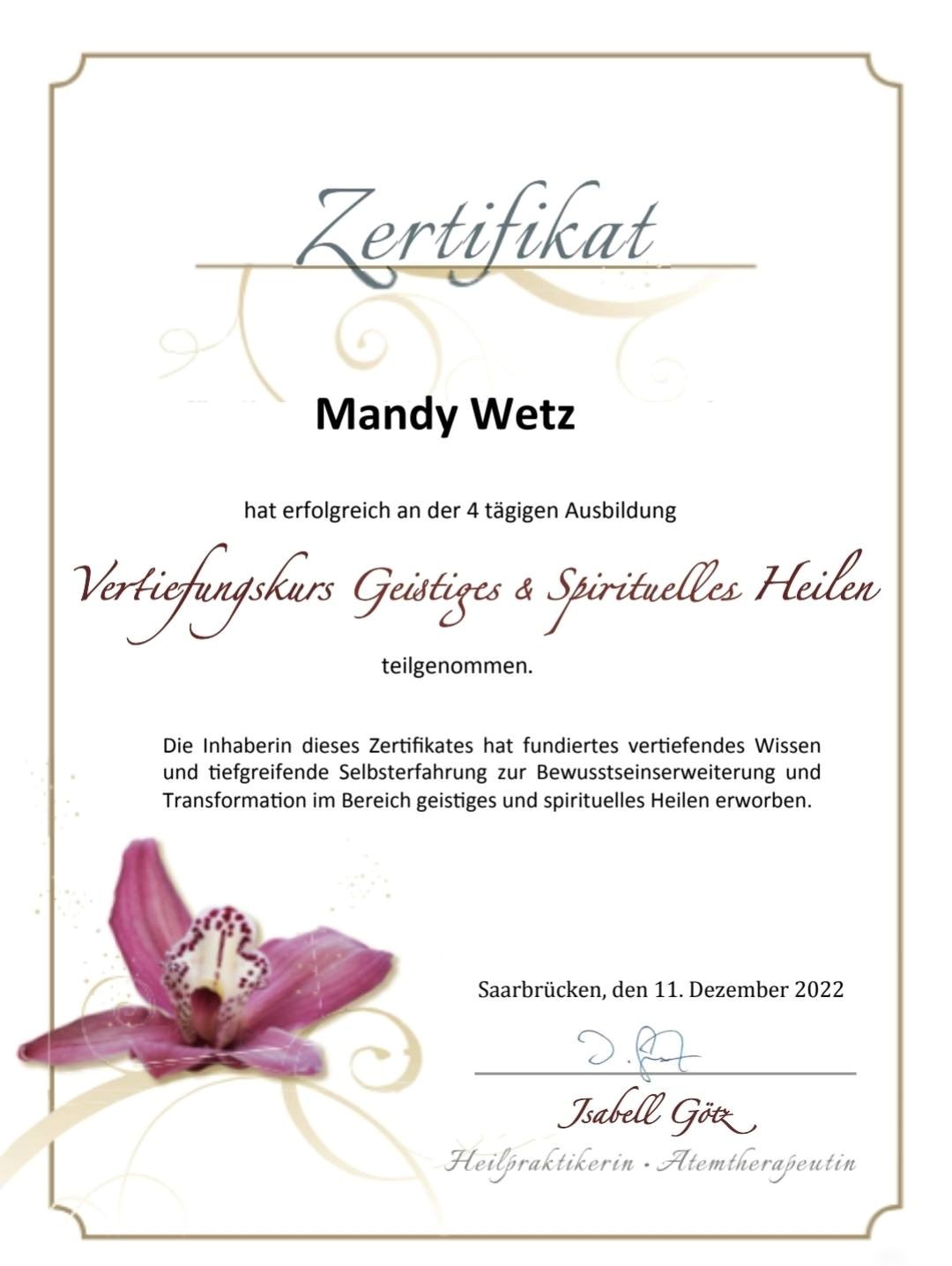 Zertifikat für Mandy Wetz für die Teilnahme an einem Kurs zum geistigen und spirituellen Heilen, mit einer pinken Blume im unteren linken Bereich.