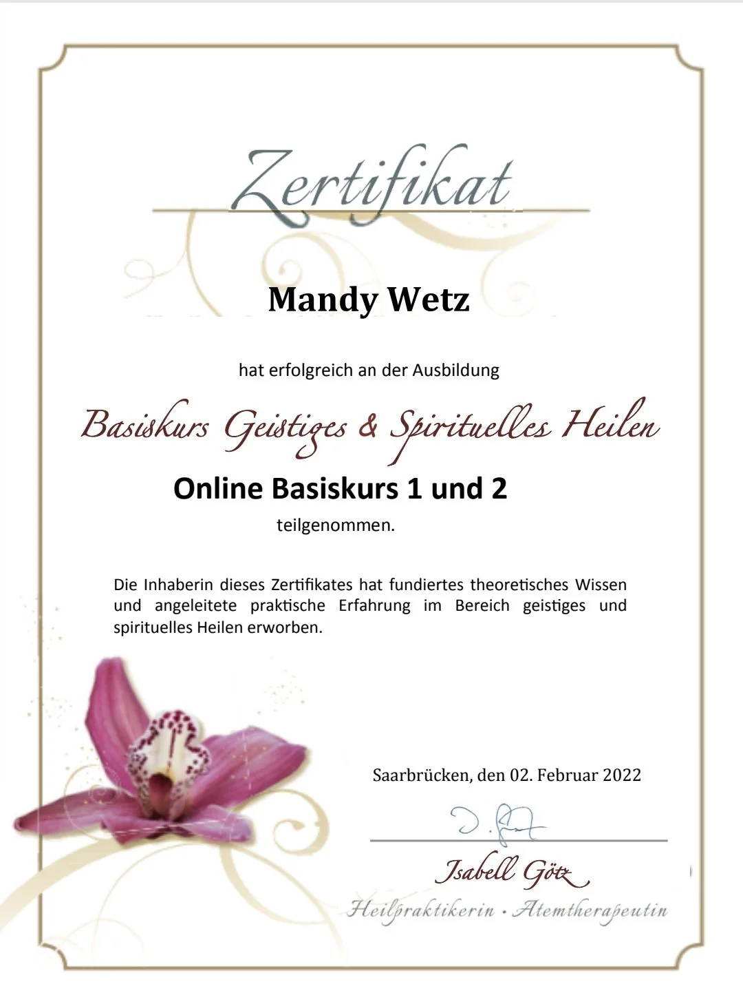 Zertifikat für Mandy Wetz für die erfolgreiche Teilnahme am Online-Basis-Kurs 'Geistiges & Spirituelles Heilen', mit einer Blumenmotive im unteren linken Bereich, Unterschrift und Datum.
