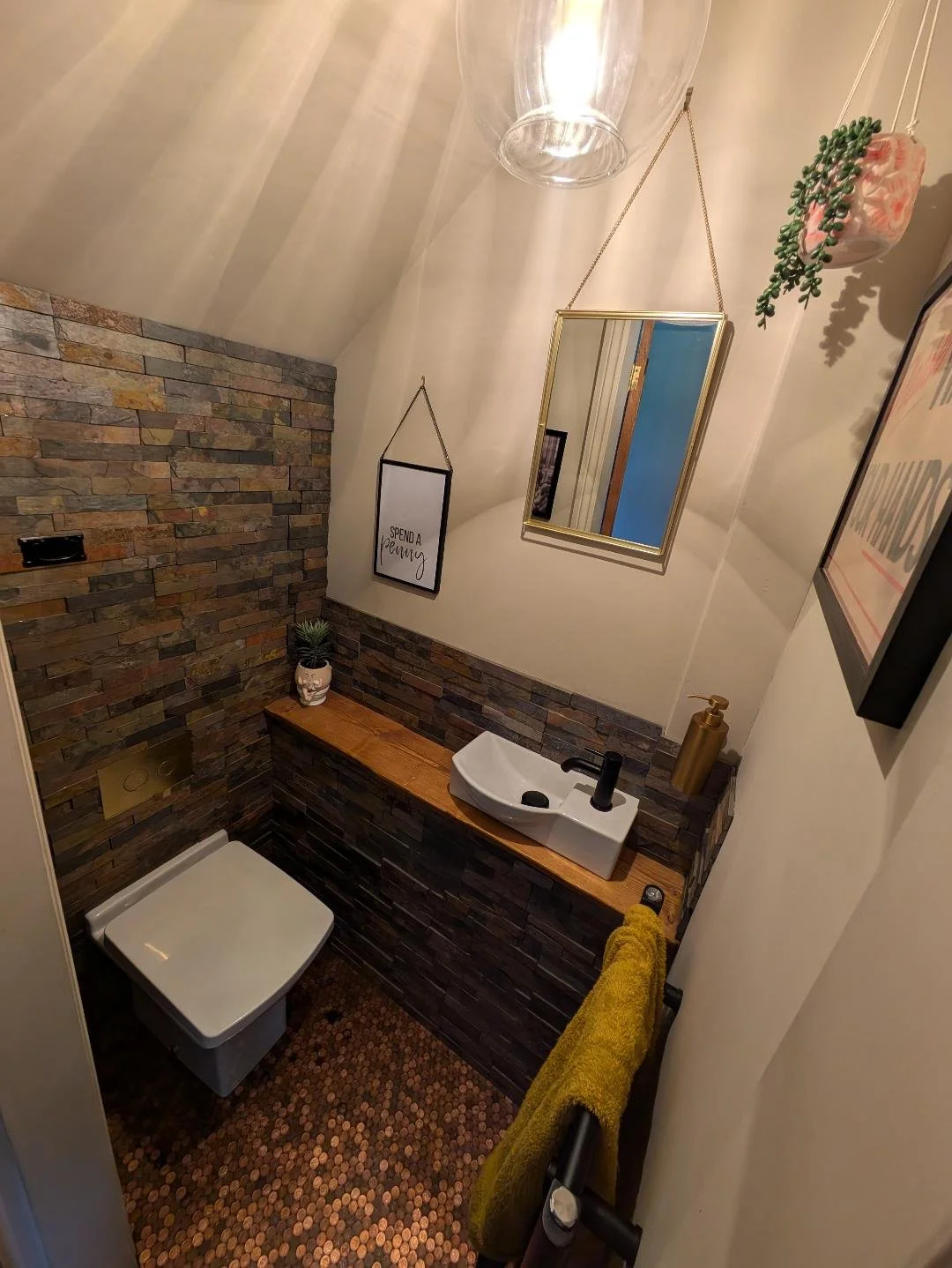 WC with slate split face tiles and a penny floor
