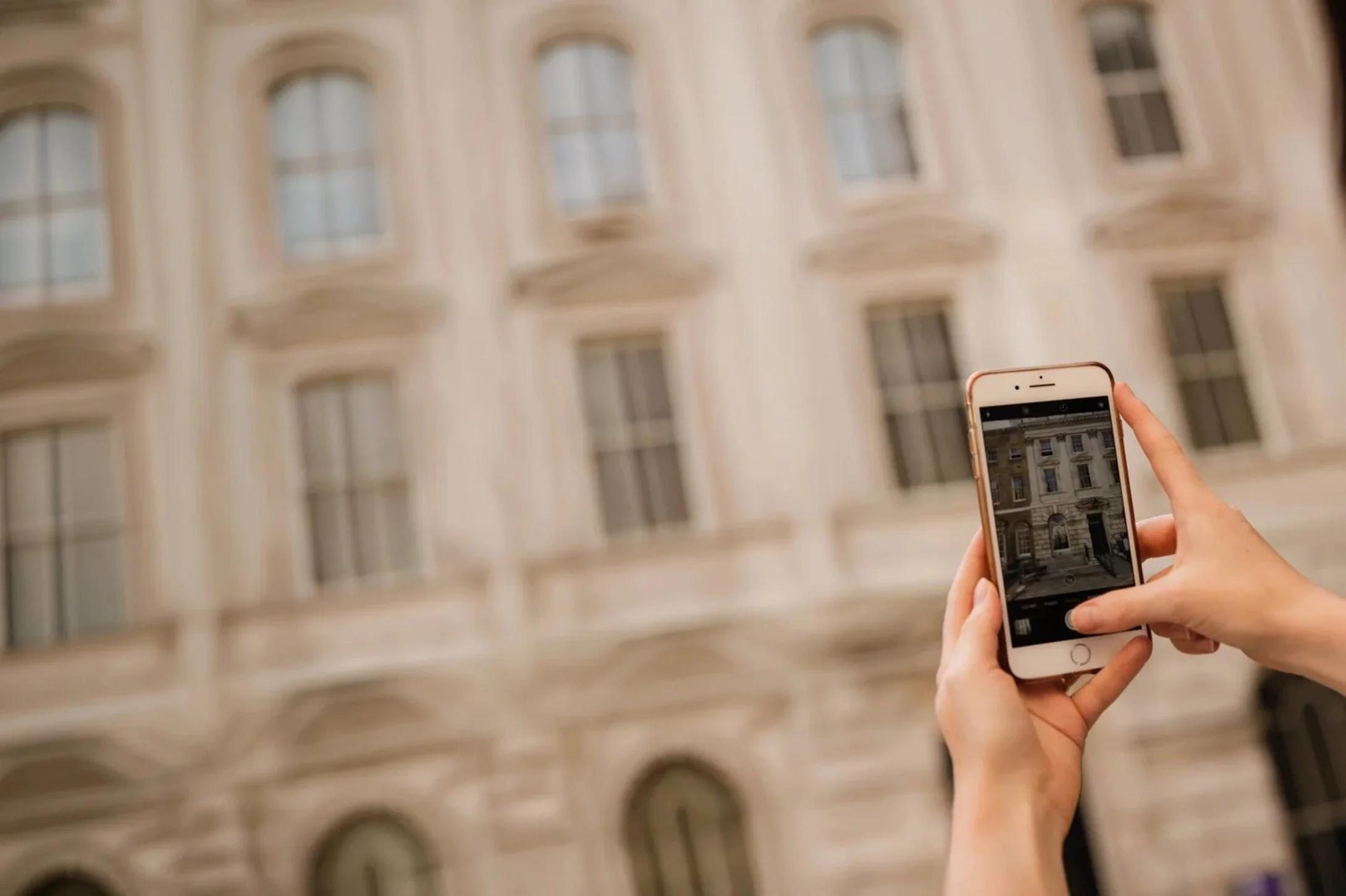 Person photographing a period building with a smartphone for digital marketing content