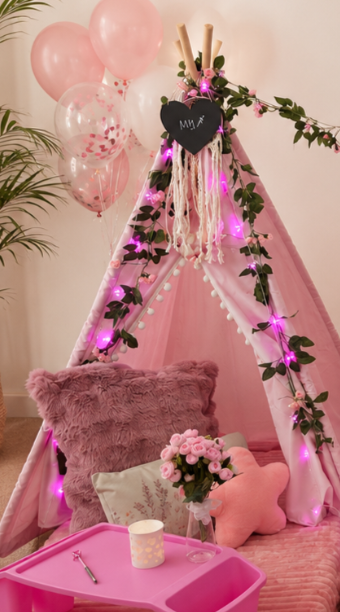 Pink teepee slumber party set-up with fluffy cushions, blankets and rugs. Decorative balloons and flowers.  Teepee slumber parties Geelong.