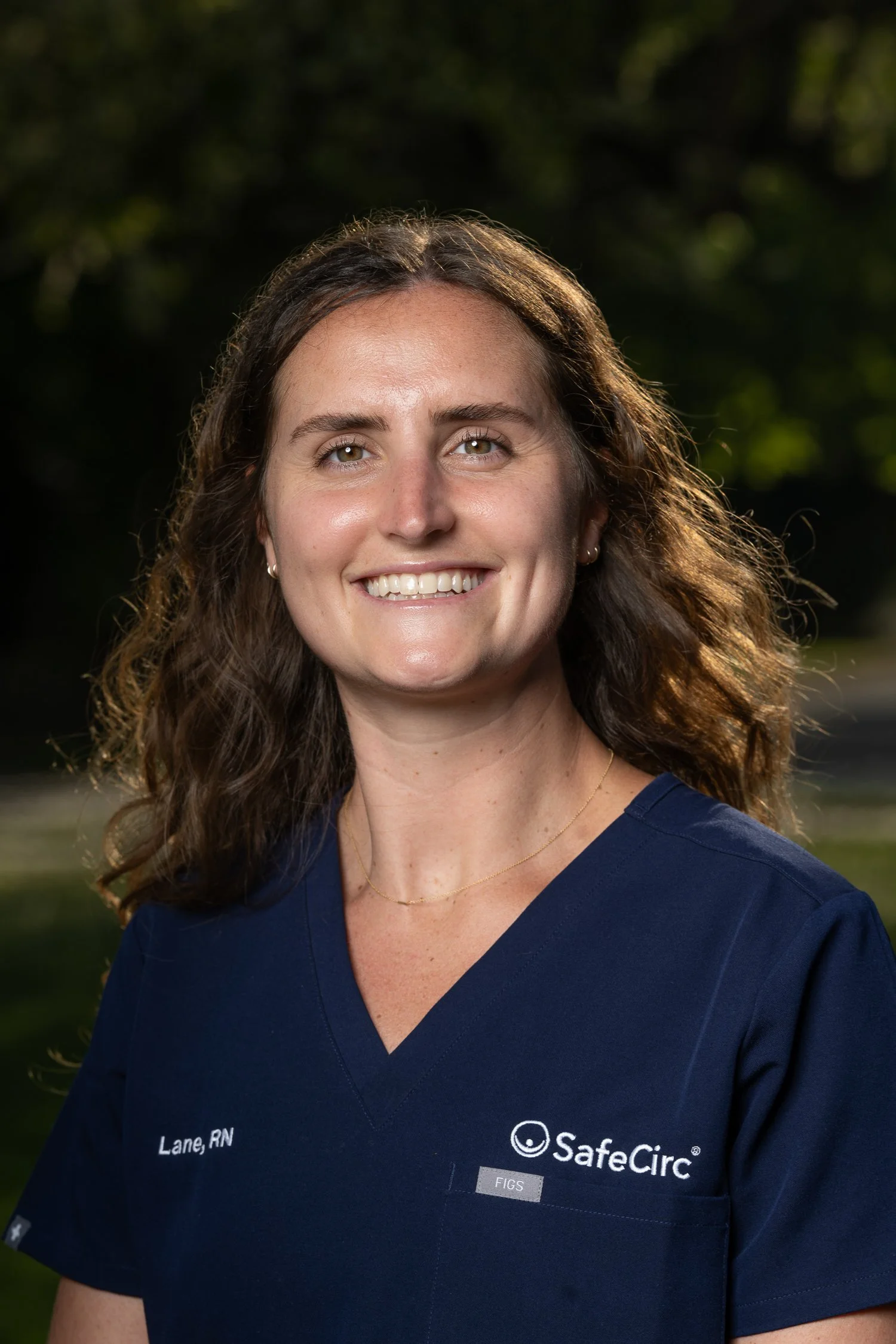Headshot of Lane West, RN, BSN wearing a navy blue medical scrub top with SafeCirc logo