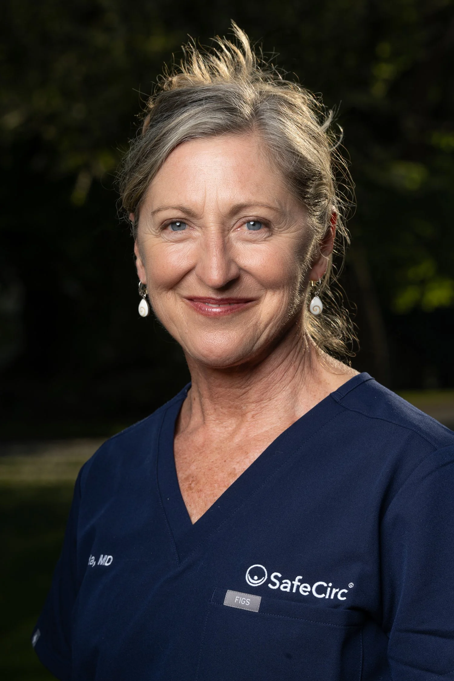 Headshot of Carla Cesario, MD wearing a navy blue medical scrub top with SafeCirc logo