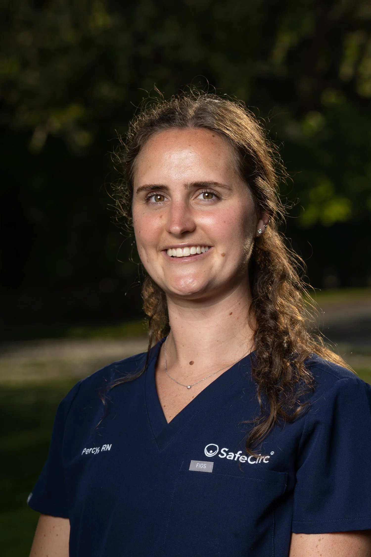 Headshot of Percy West, RN, BSN wearing a navy blue medical scrub top with SafeCirc logo