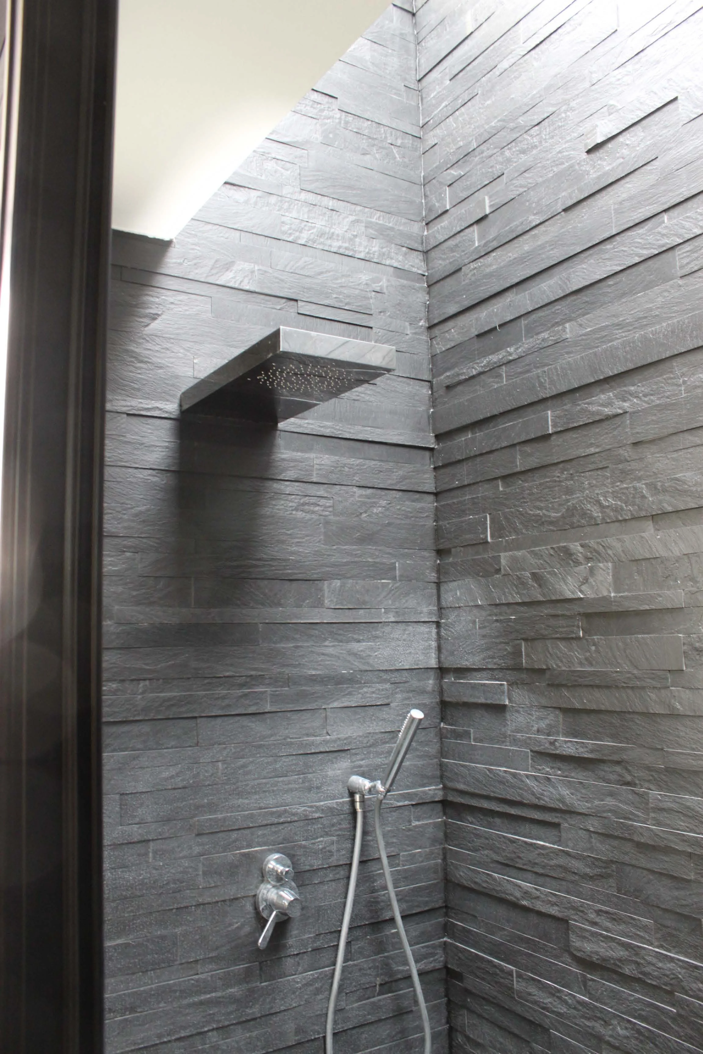 Walk in shower with Sauna with dark grey natural wall stone. South Kensington House