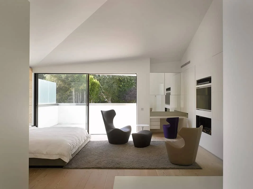Minimalist bedroom with B&B Italia furniture and sliding door to the rear courtyard. Sheldon Avenue House, Hampstead.