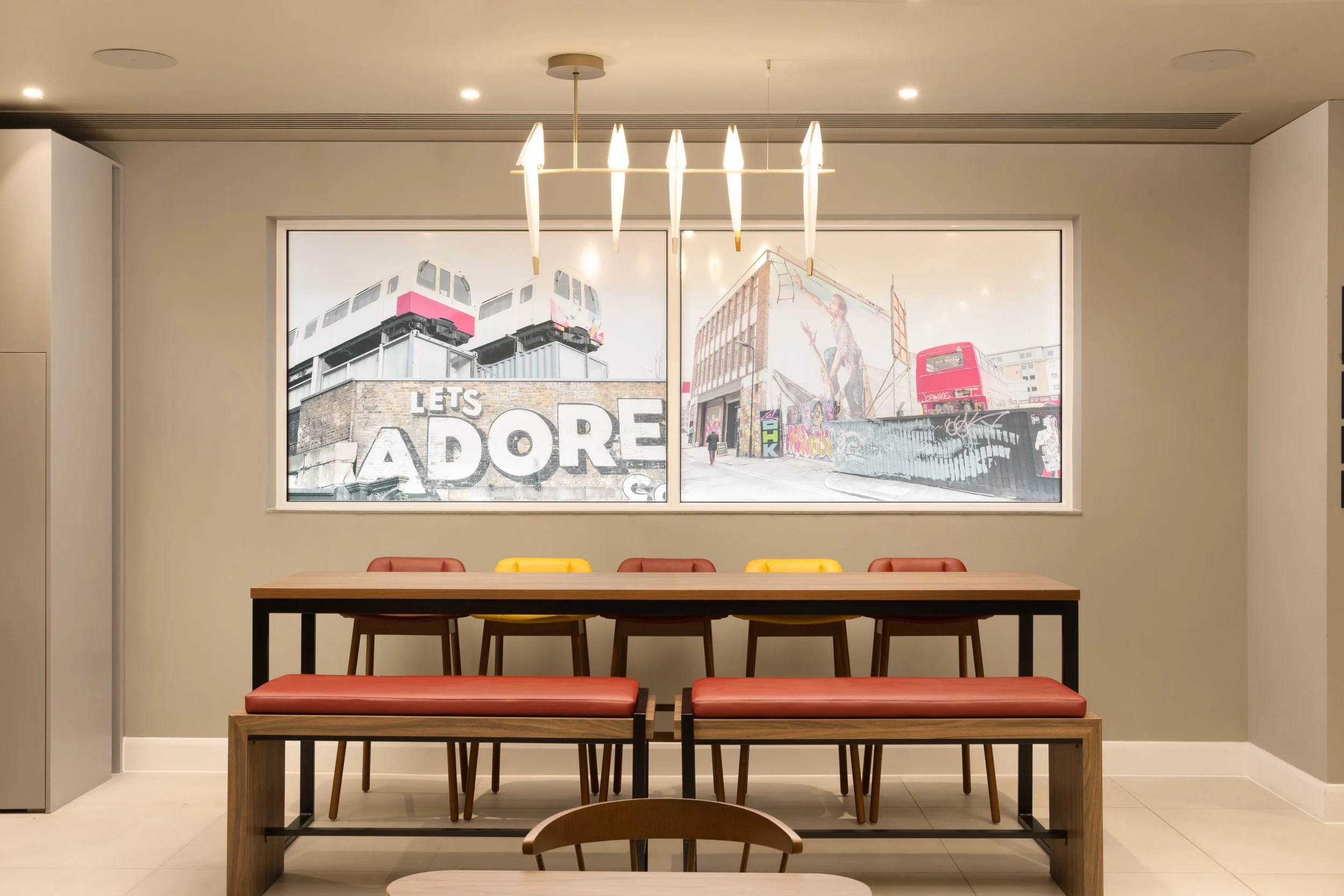 A room with a large window showing graffiti art and murals of London in the ground floor public areas of the Hampton by Hilton Hotel in Old Street