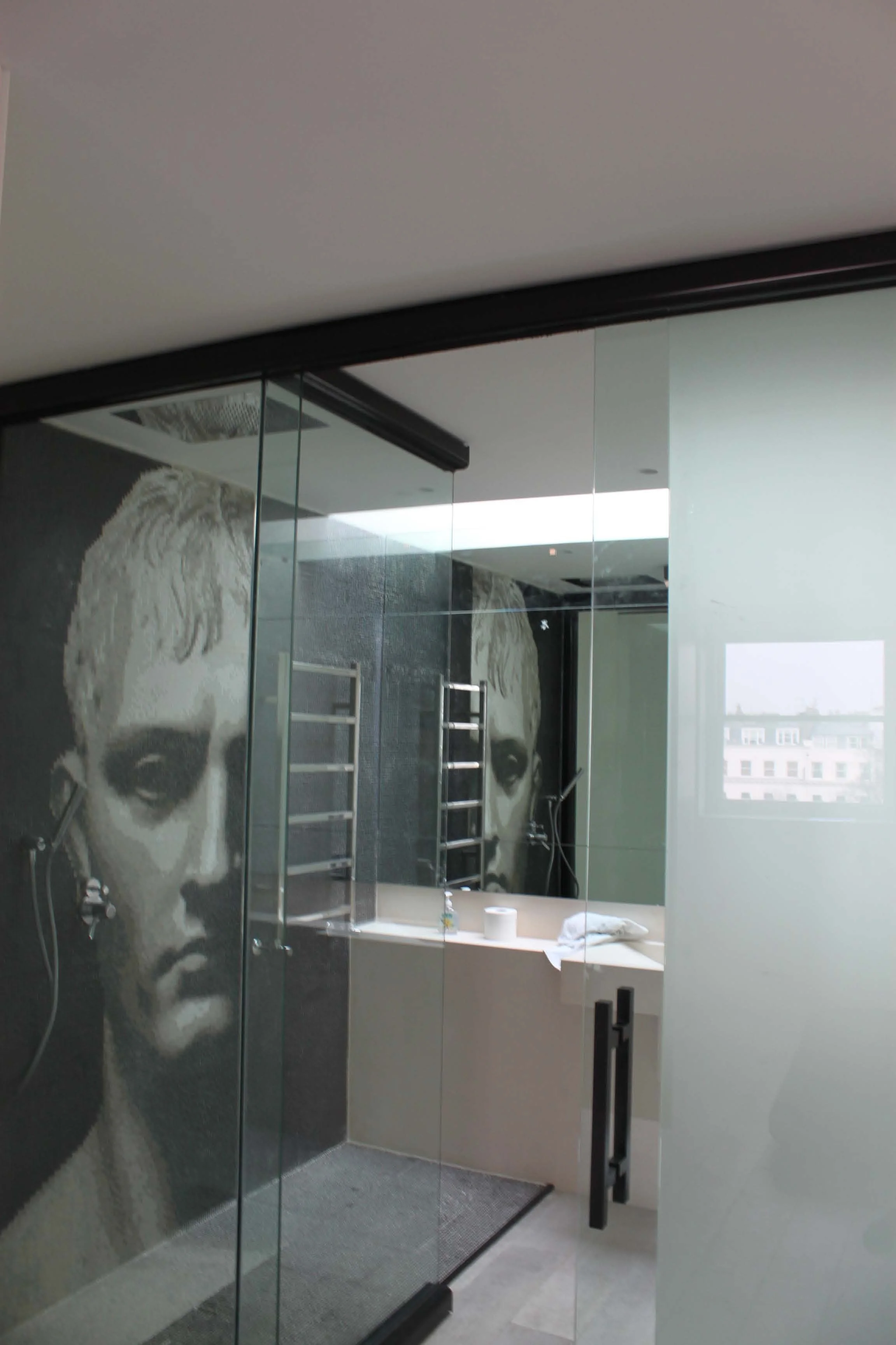 View of the bathroom special design wall tiles , walking shower, modern bathroom with grey tiled floors and purpose design marble sink. South Kensington House