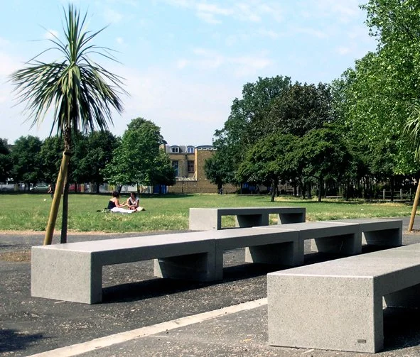 Custom-designed smooth concrete benches, with palm trees, in front of the new Children's Centre in Paradise Park.