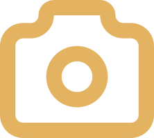 An icon of a camera in gold color with a black background.