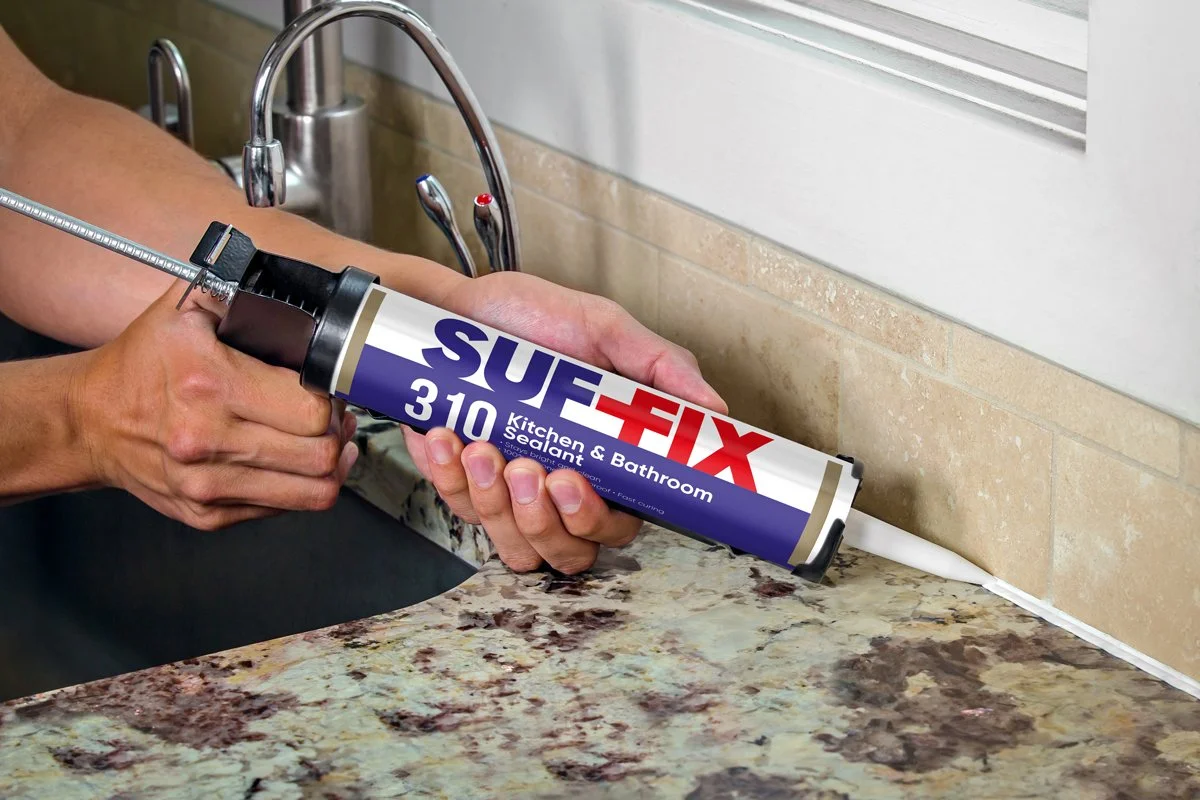 A person applying Kitchen & Bathroom Sealant using a caulking gun, with a label reading 'Suf Fix 310'.