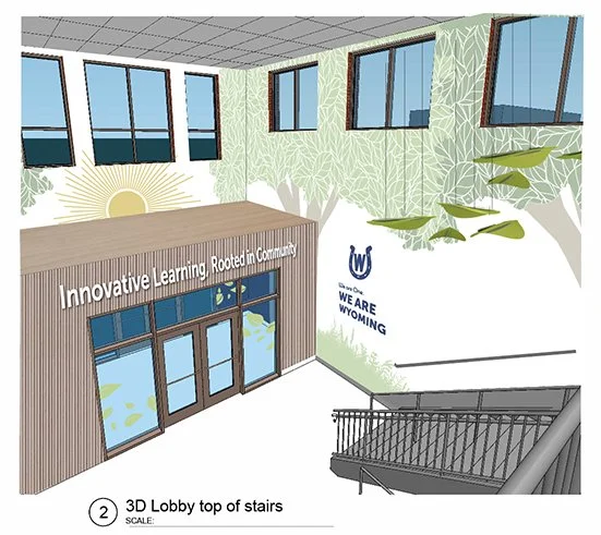 Interior view of a building lobby with several windows on the upper walls, a mural of trees and a sun on the wall, and a sign that reads "Innovative Learning. Rooted in Community". A staircase with a black railing leads down from the balcony area, an