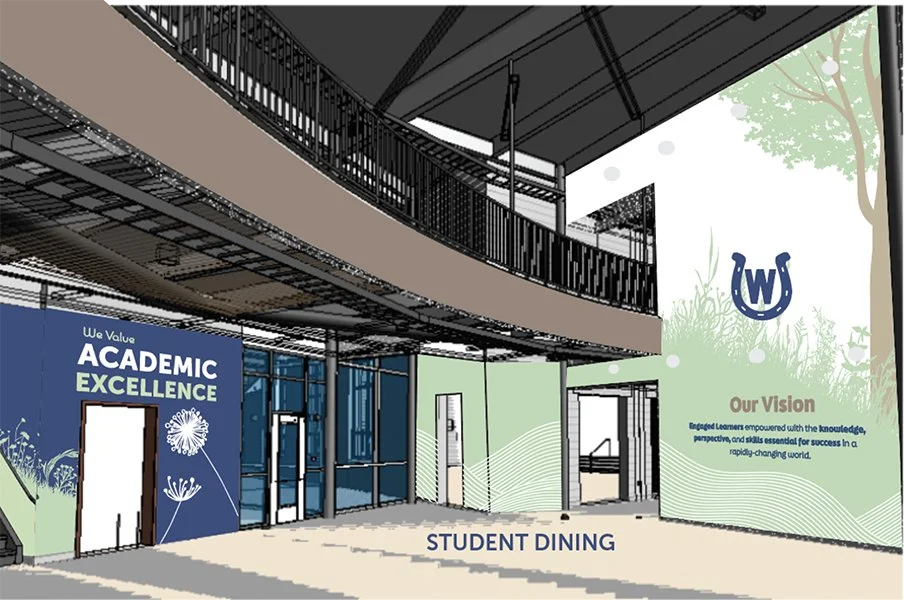 An indoor area with a sign that reads 'We Value Academic Excellence' and a wall with the school's vision statement. There is a higher level with a railing, and a sign indicating 'Student Dining'. The decor includes trees and natural elements.