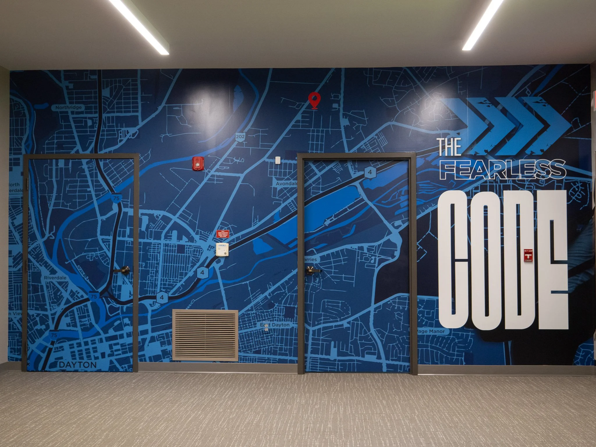 Blue wall mural with a detailed city map of Riverside, Ohio, including streets and roads, with the words 'The Fearless Code" visible.