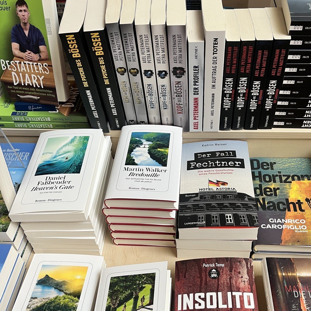 Buchregal mit mehreren Büchern, darunter Titel von Diogenes und, Katrin Reiser auf einem Verkaufstisch