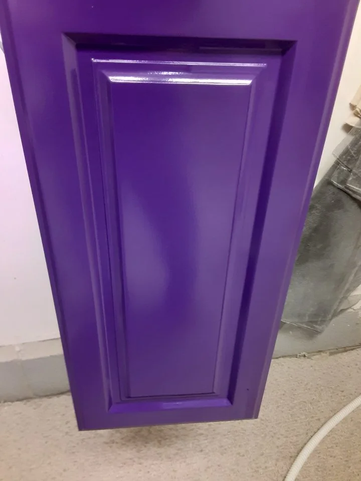 Purple painted raised-panel cabinet door with a glossy finish, completed by a professional cabinet painter in Waxhaw, North Carolina.