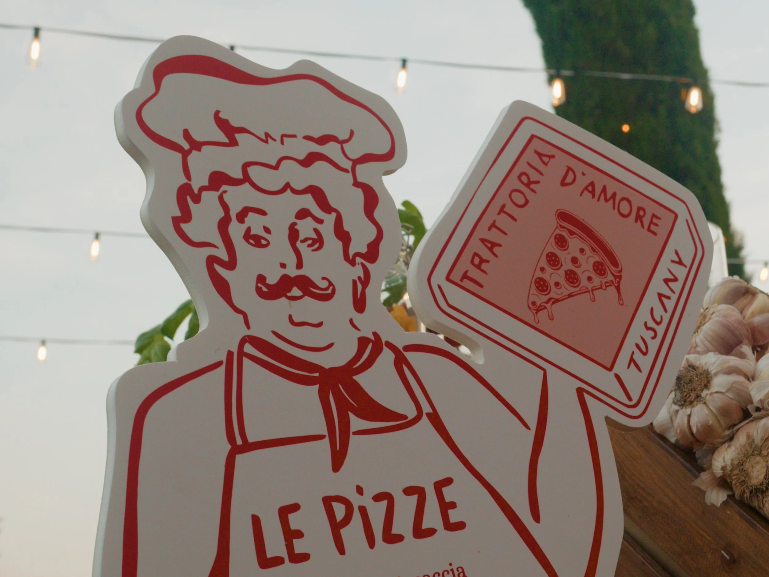 A sticker of a caricature of a man with a beard and mustache, with part of a pizza illustration and the words 'Fast To More,' 'Amo,' 'Pizza,' and 'Le Pizza' visible.