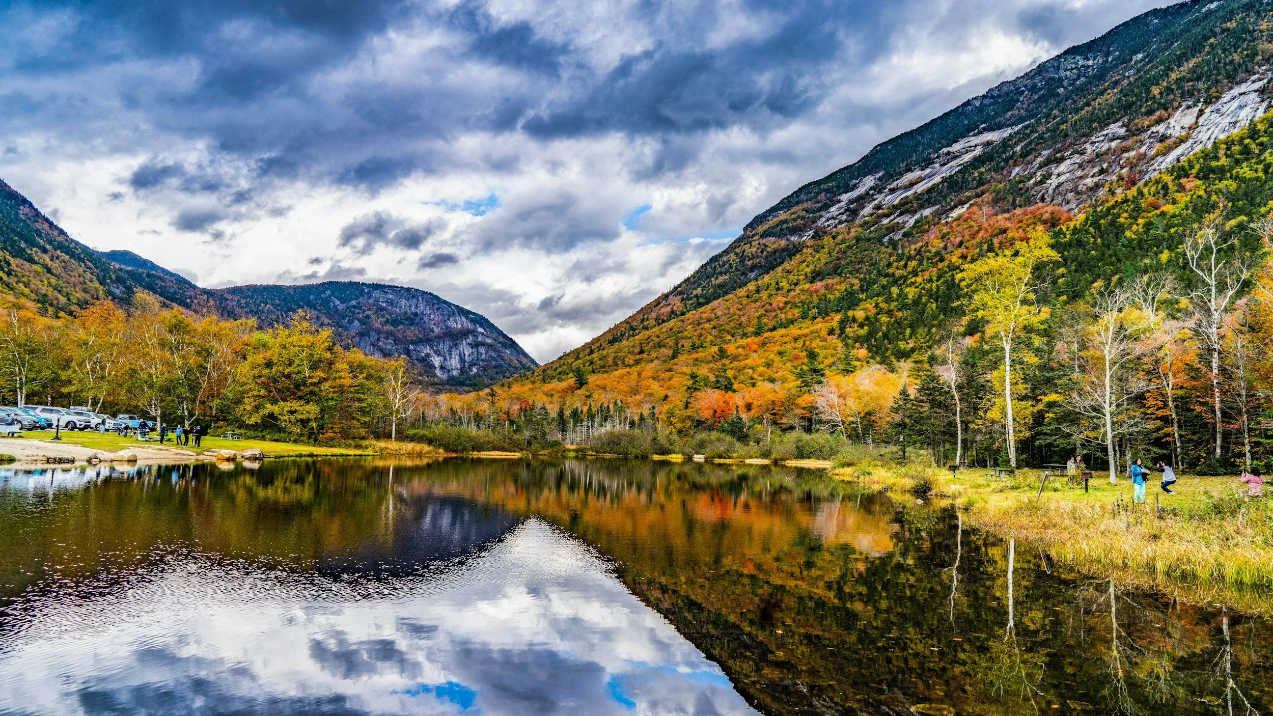 Lake in new hampshire with fall foliage on the mountains in the background